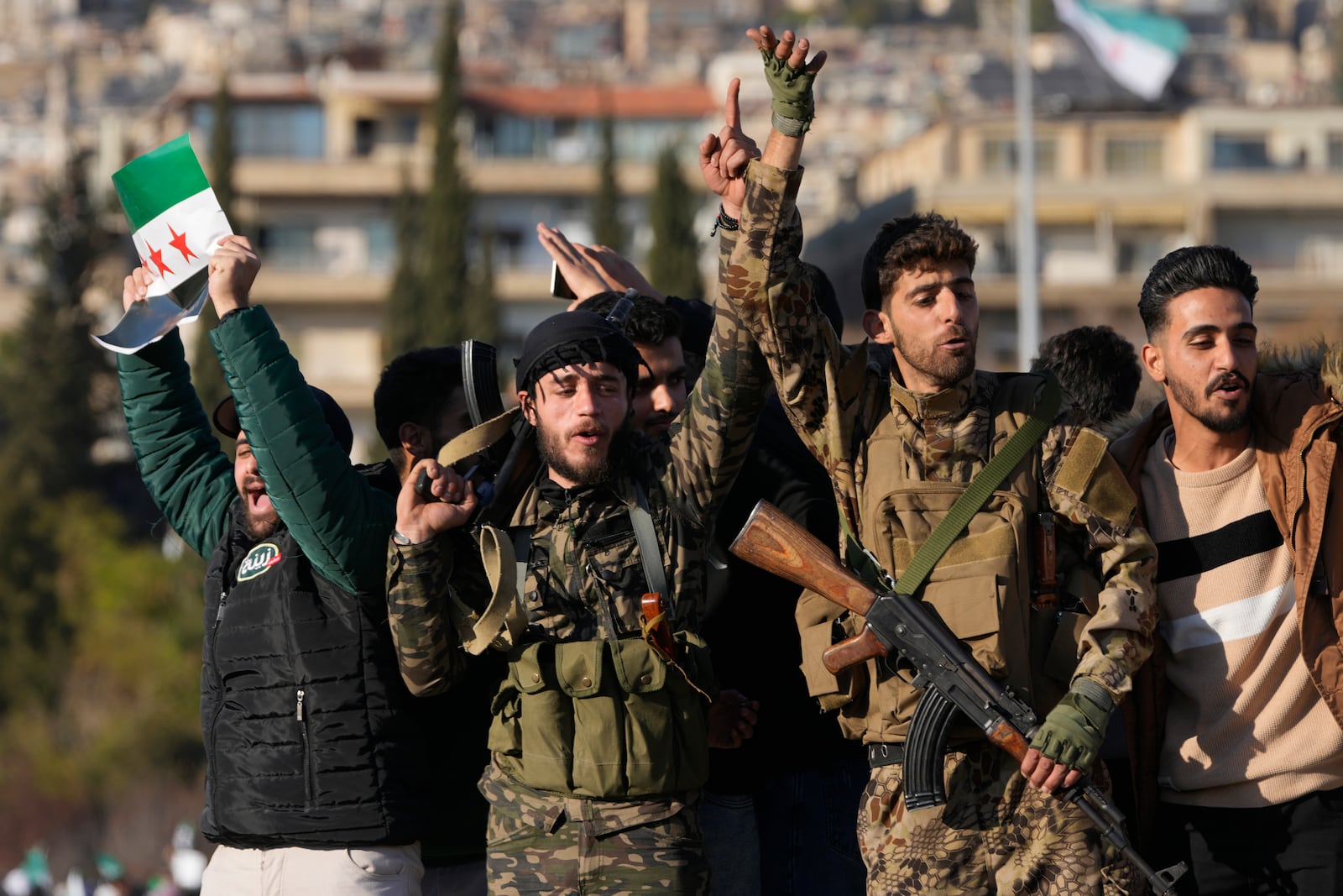 Syrian members of the rebel group celebrate during a demonstration following the first Friday prayers since Bashar Assad's ouster, in Damascus' central square, Syria, on Friday, Dec. 13, 2024. (AP Photo/Hussein Malla)