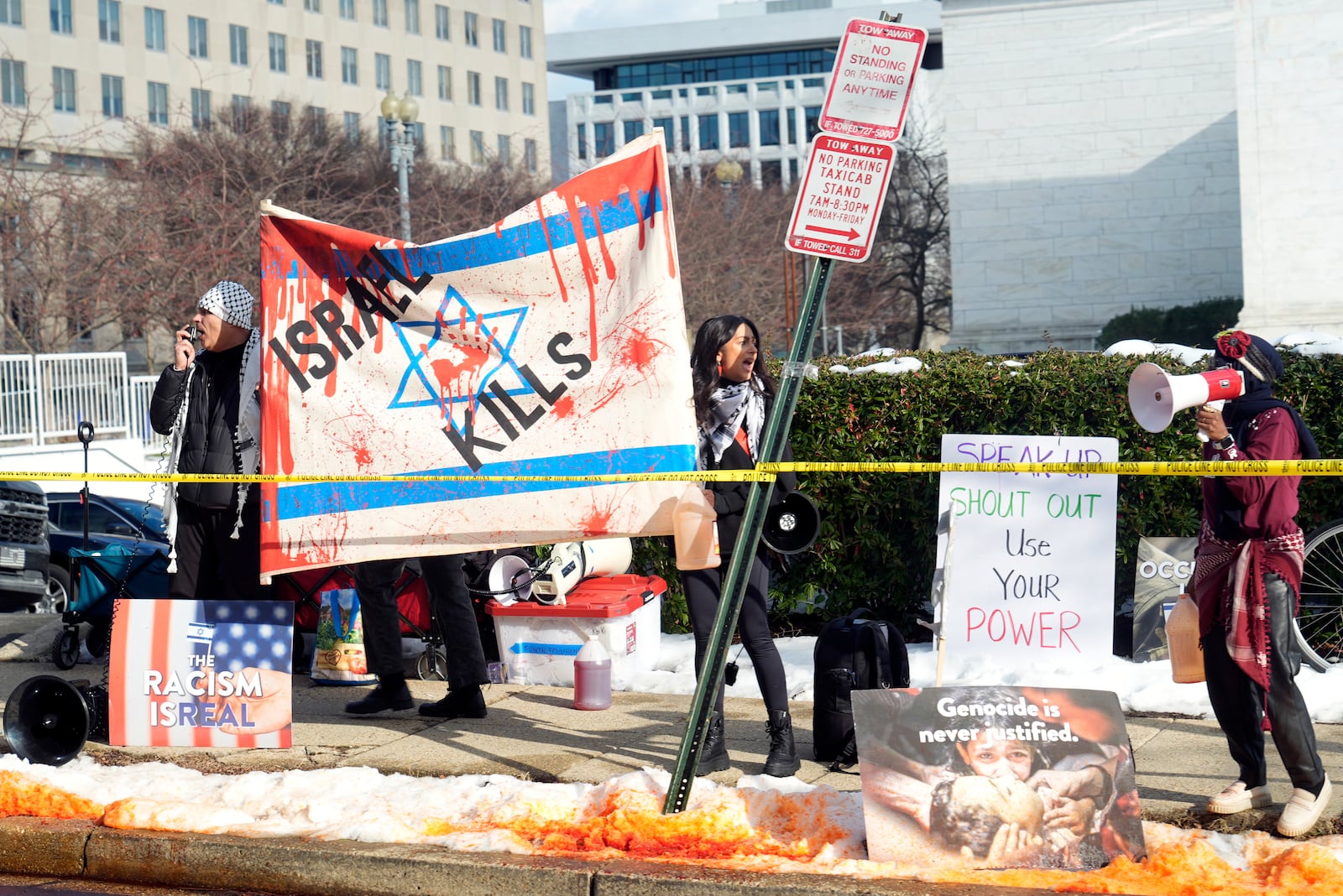 Protesters line the street as President Joe Biden's motorcade passes on its way to the State Department for Biden to speak about foreign policy in Washington, Monday, Jan. 13, 2025. (AP Photo/Susan Walsh)