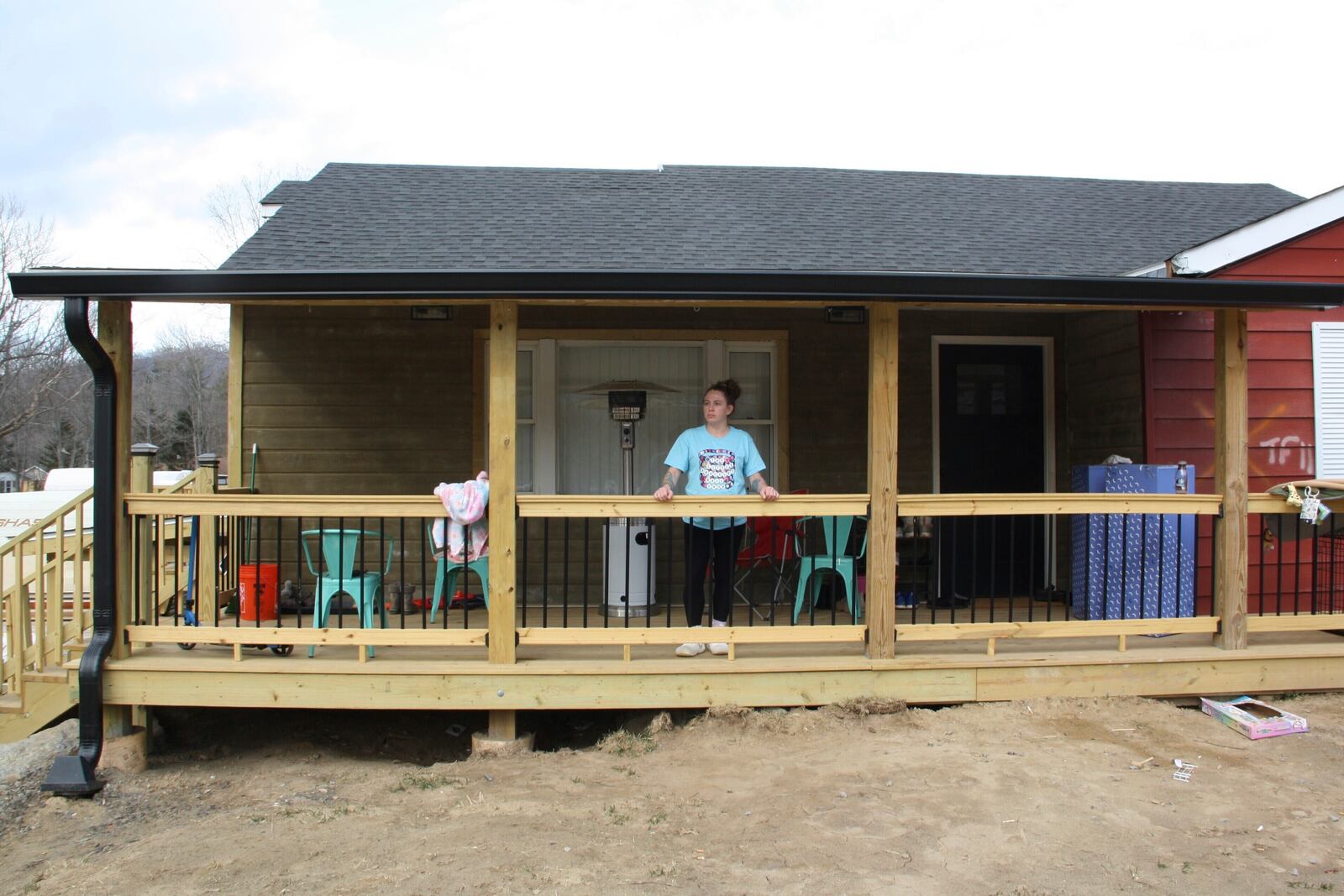 Emily Russell stands on her new porch overlooking her front yard in Swannanoa, N.C., on Thursday, Feb. 6, 2025. (AP Photo/Makiya Seminera)