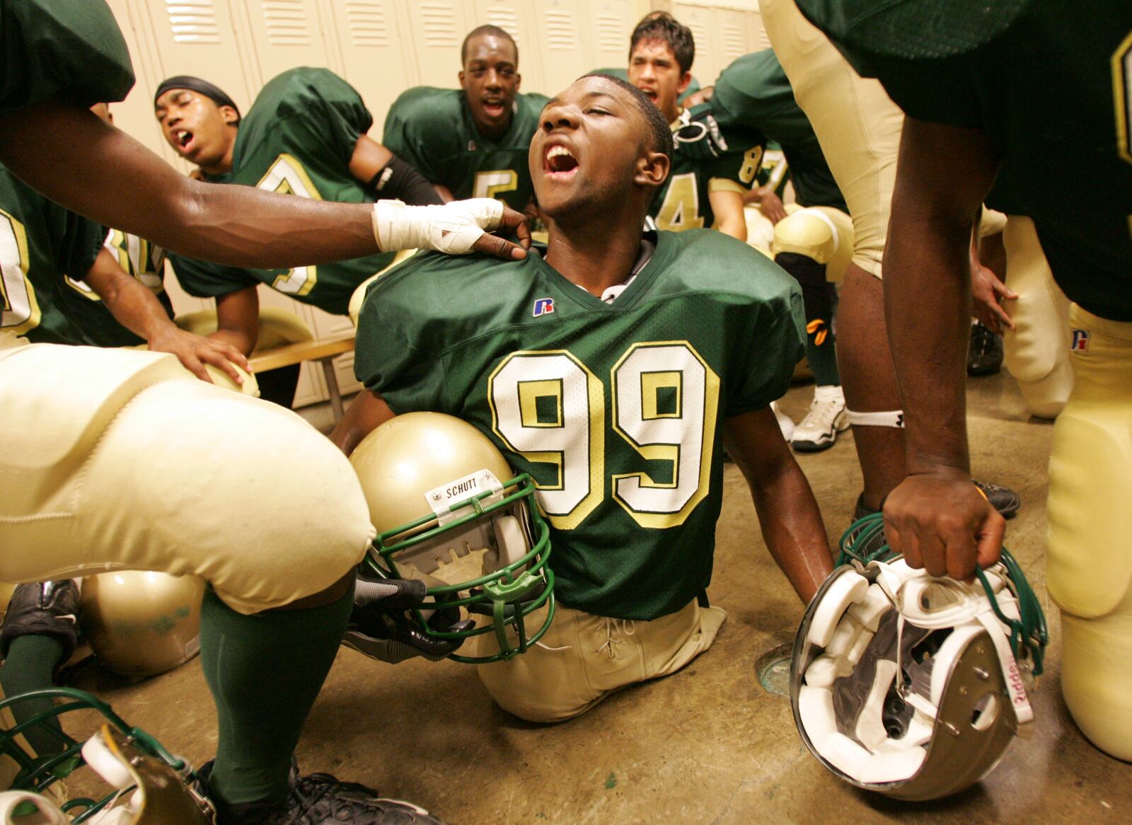 Colonel White's Bobby Martin is in the midst of teammates as they chant a spirited response to a coaches' inspirational speech in the locker room before a game with Dunbar. Photo by Jim Witmer