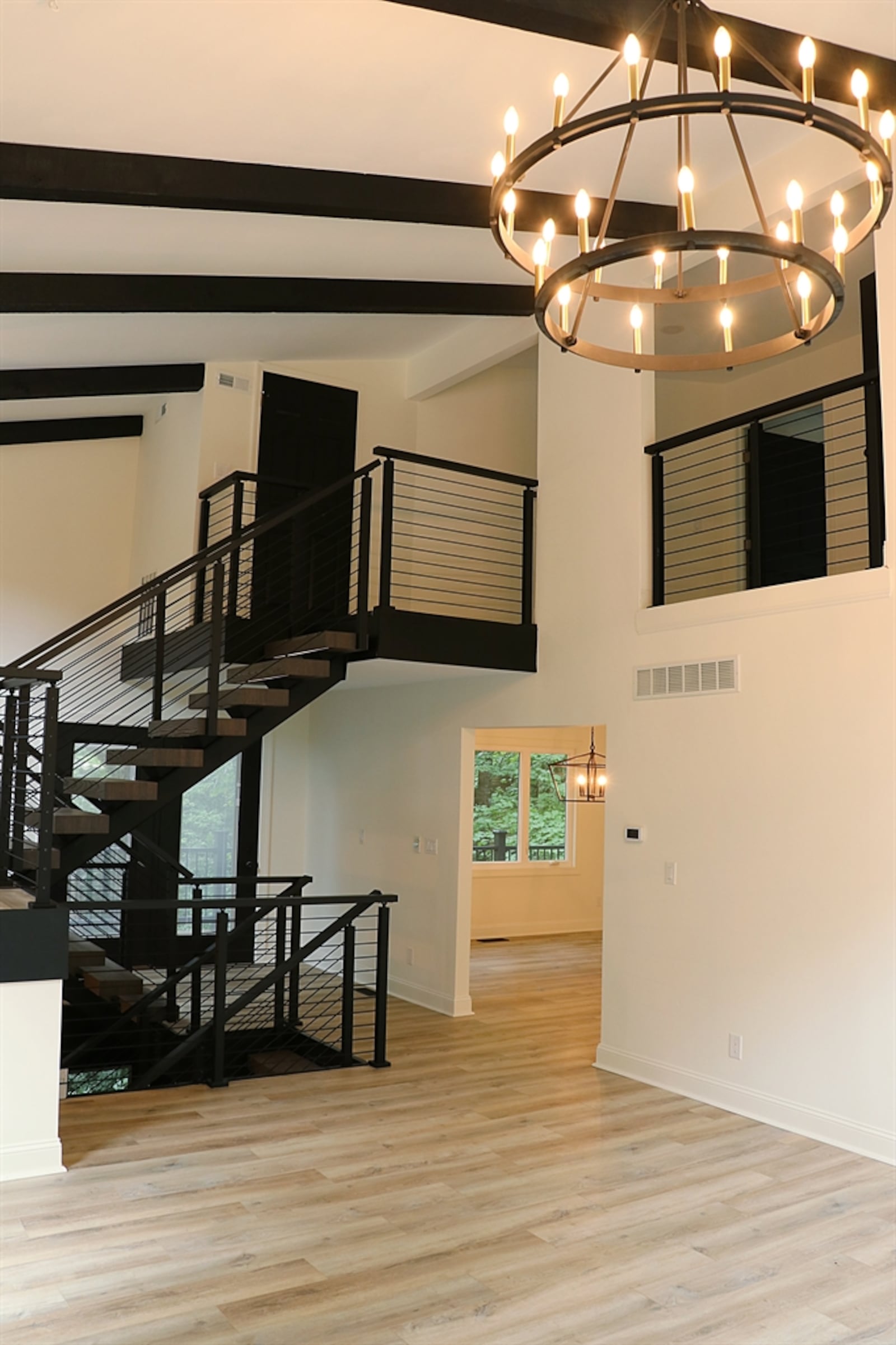 The centerpiece to the home and the redesign is the illuminated floating staircase with a metal banister, wire-like railings and wooden broad plank steps. 