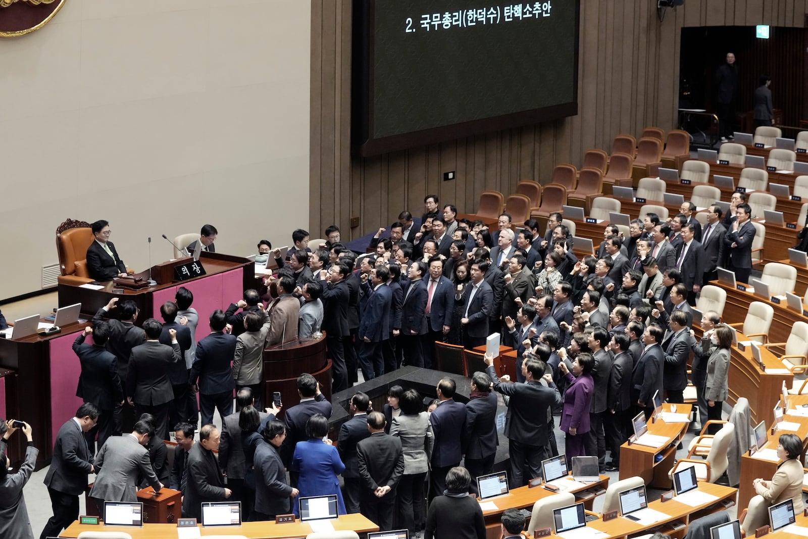 Lawmakers of the ruling People Power Party protest to South Korea's National Assembly Speaker Woo Won Shik, top left, during a plenary session for the impeachment motion against South Korean acting President Han Duck-soo at the National Assembly in Seoul, South Korea, Friday Dec. 27, 2024. (AP Photo/Ahn Young-joon)