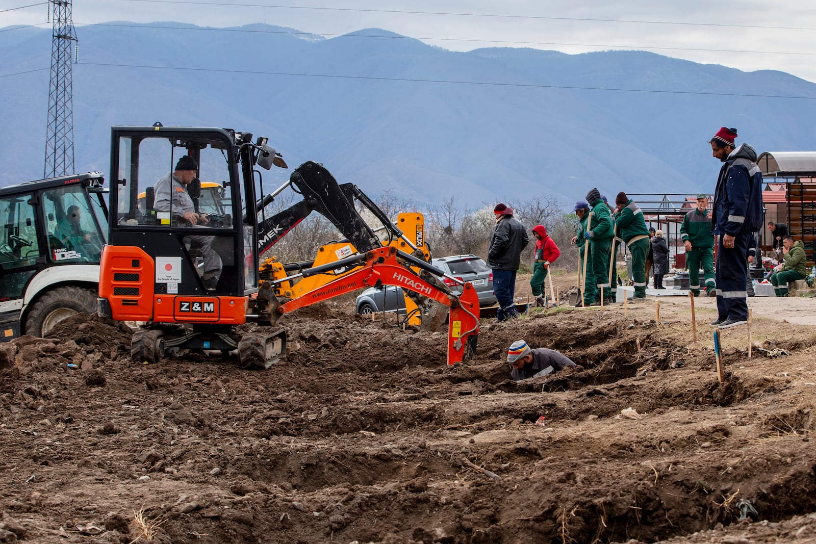 Workers dig graves for the victims of a massive nightclub fire in the town of Kocani, North Macedonia, Tuesday, March 18, 2025. (AP Photo/Visar Kryeziu)