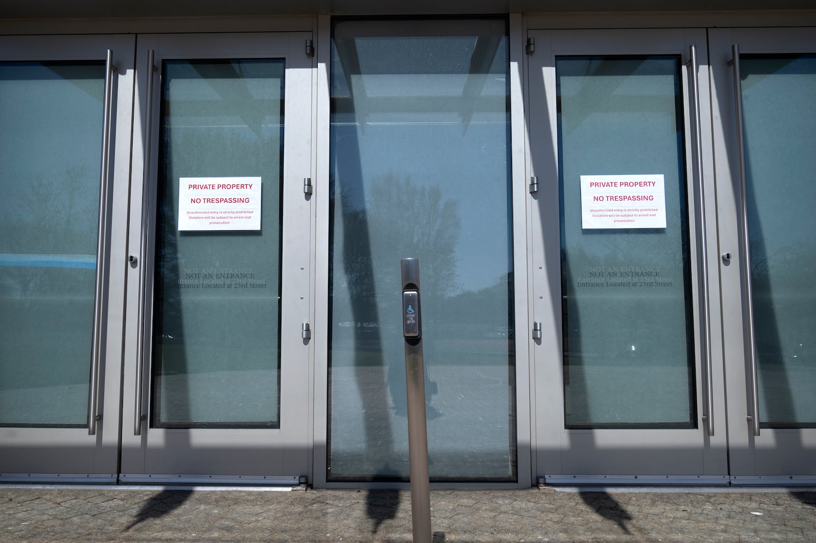 No trespassing signs are posted on doors at the headquarters of the United States Institute of Peace, Tuesday, March 18, 2025, in Washington. (AP Photo/Mark Schiefelbein).