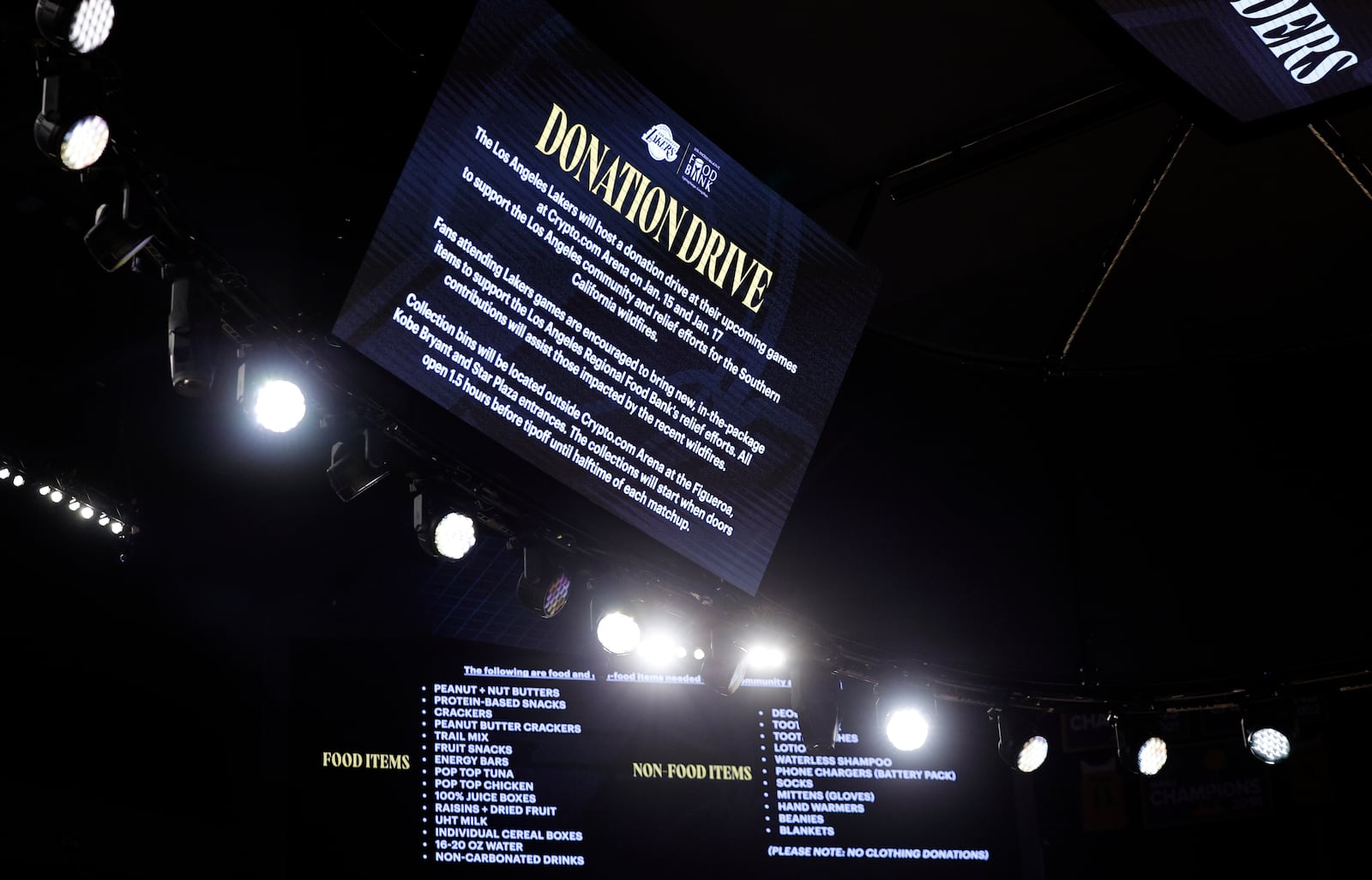 Signs announce the Los Angeles Lakers donation drive for California wildfires victims before an NBA basketball game against the San Antonio Spurs, Monday, Jan. 13, 2025, in Los Angeles. (AP Photo/Kevork Djansezian)