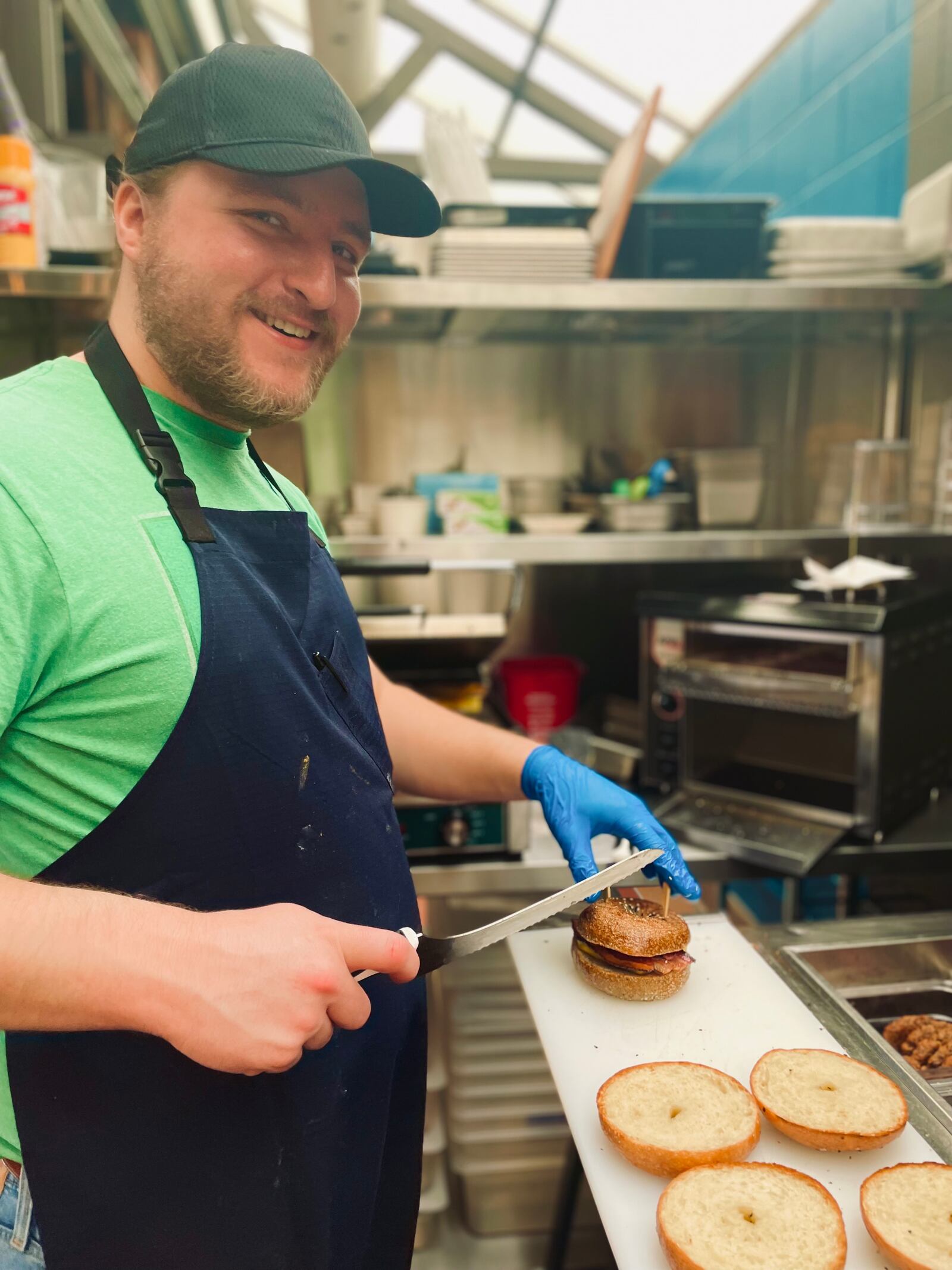 Nicholas Bisaha prepares a bagel sandwich at DOUGH, A bakery by Ghostlight at 2nd Street Market.