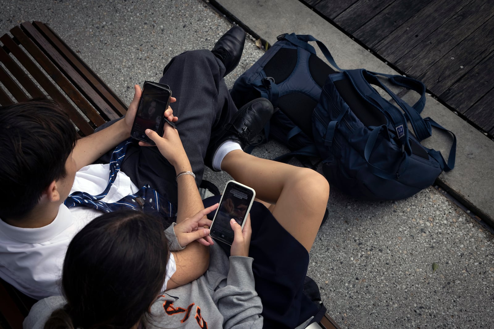 FILE — Schoolchildren with their mobile phones in Sydney, Australia, on Feb. 24, 2021. Australian legislators last month voted to ban social media accounts for teens and adolescents under age 16.. (Matthew Abbott/The New York Times)
                      