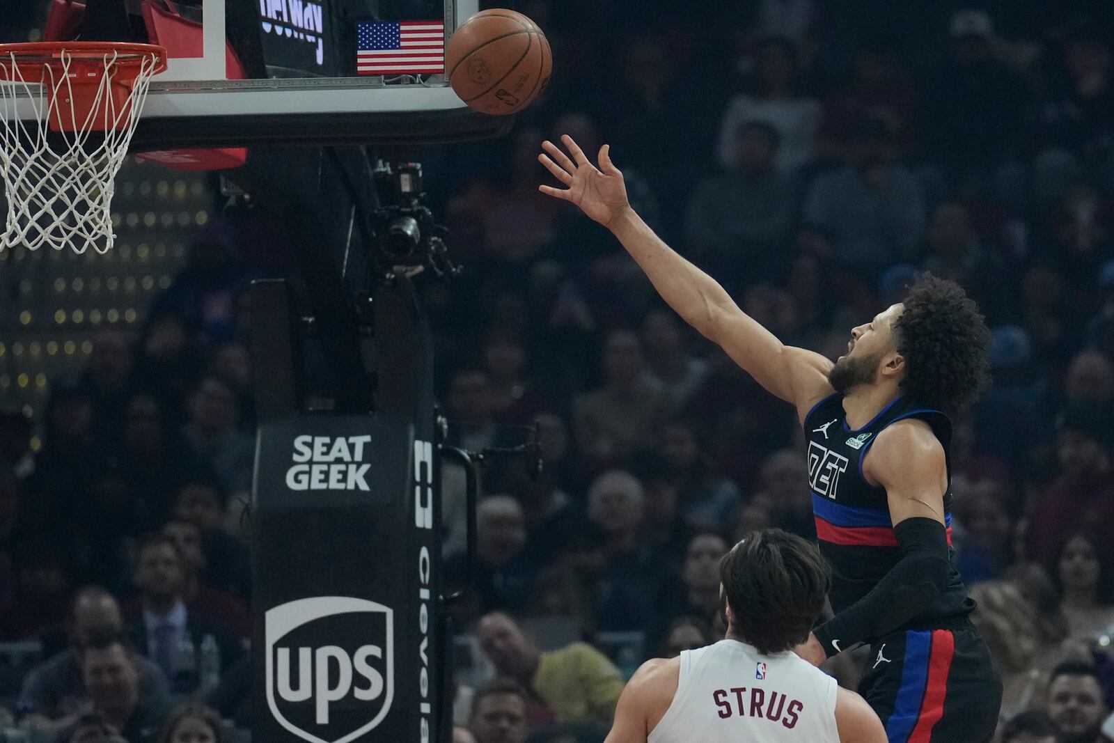 Detroit Pistons guard Cade Cunningham, right, shoots in front of Cleveland Cavaliers guard Max Strus, left, in the first half of an NBA basketball game, Monday, Jan. 27, 2025, in Cleveland. (AP Photo/Sue Ogrocki)