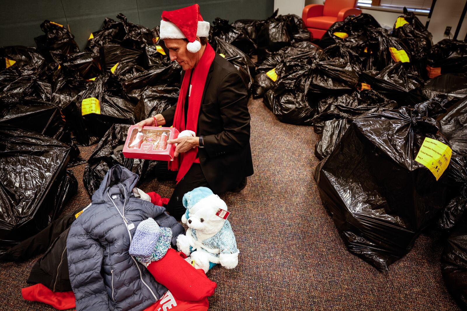 Dayton attorney, Doug Mann checks out a bag of Christmas presents donated to Montgomery County Children Services Monday Dec. 13, 2021. Mann's firm,  Dyer, Garofalo, Mann and Schultz started the FLOC program in the 1980s which gives Christmas presents to under served Dayton children. JIM NOELKER/STAFF