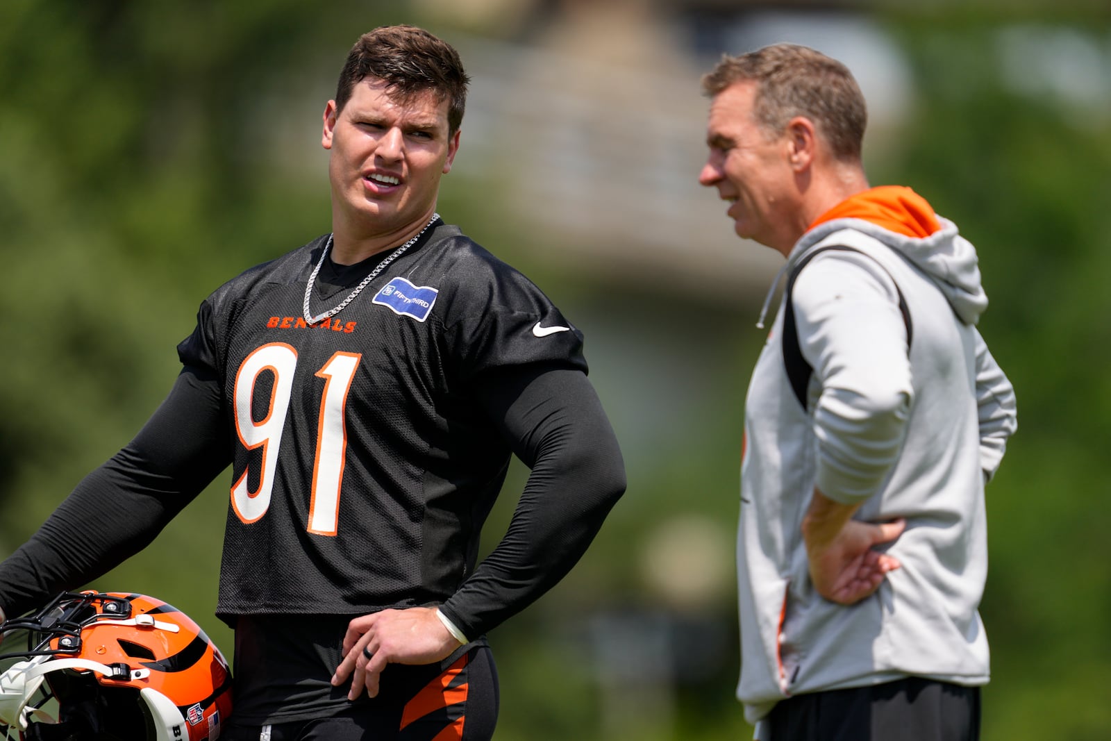 Cincinnati Bengals' Trey Hendrickson (91) speaks with defensive coordinator Lou Anarumo during NFL football practice, Tuesday, June 4, 2024, in Cincinnati. (AP Photo/Jeff Dean)