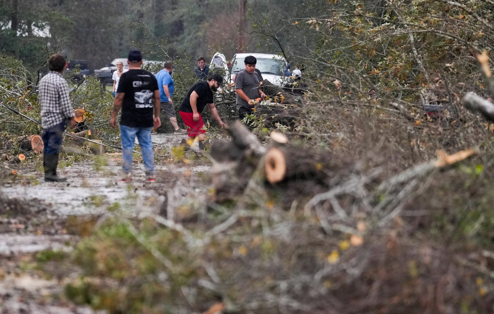 People remove debris from a street after strong thunderstorms pass through the Greater Houston region, Saturday, Dec. 28, 2024, in Porter Heights. (Jason Fochtman/Houston Chronicle via AP)