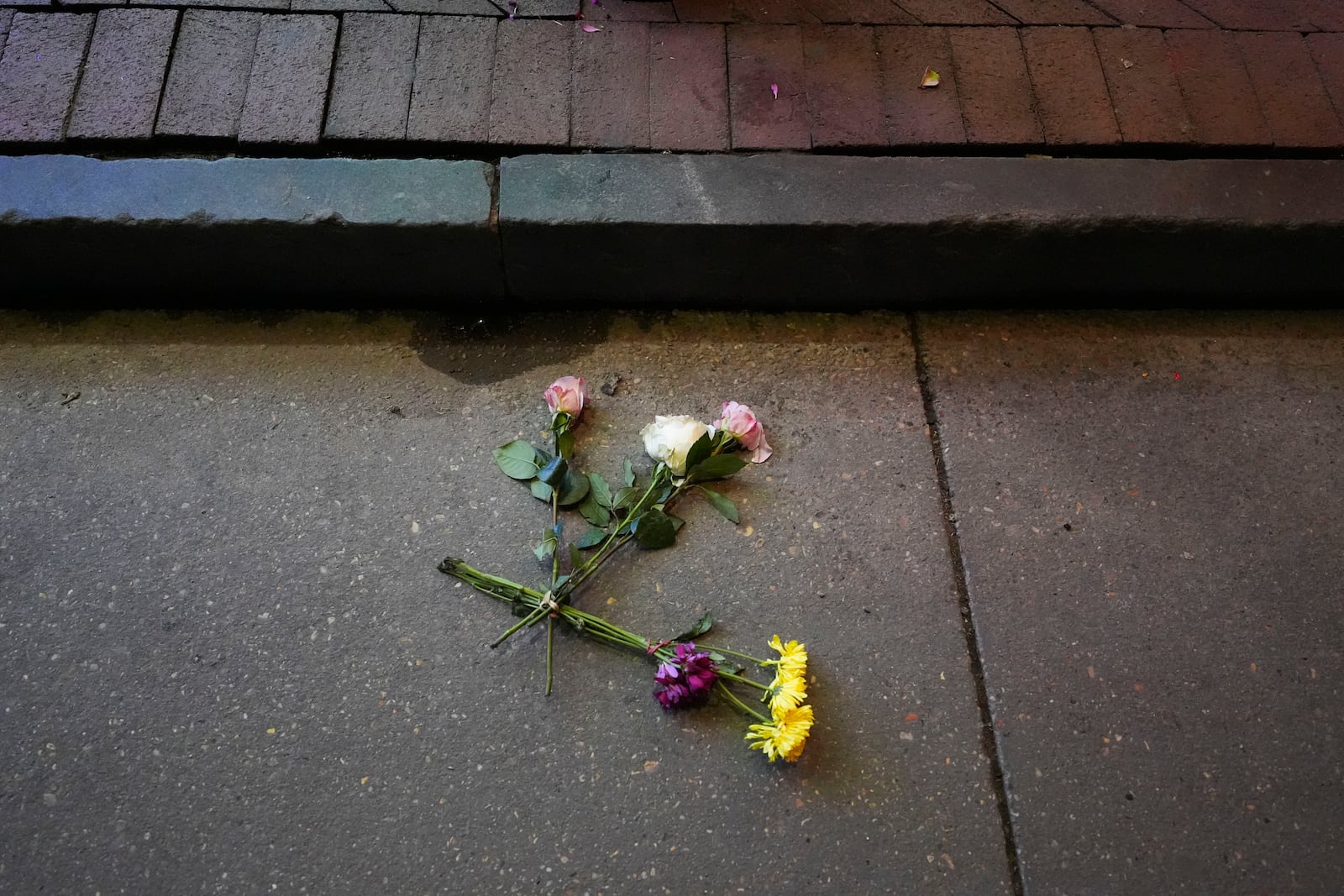 Flowers lie in the street at the site of a deadly truck attack on New Year's Day in New Orleans, Friday, Jan. 3, 2025. (AP Photo/Gerald Herbert)