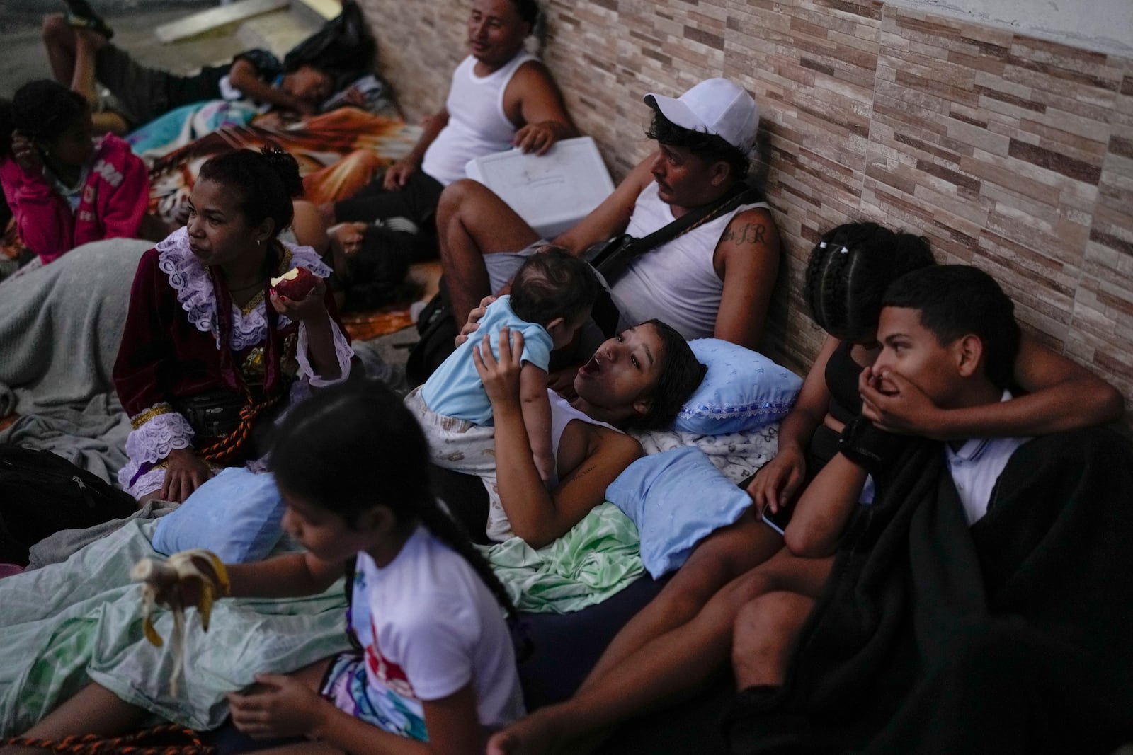 Pilgrims rest outside San Felipe Church where they came to honor the Black Christ in Portobelo, Panama, early Monday, Oct. 21, 2024, during a festival celebrating the iconic statue that was found on the shore in 1658. (AP Photo/Matias Delacroix)