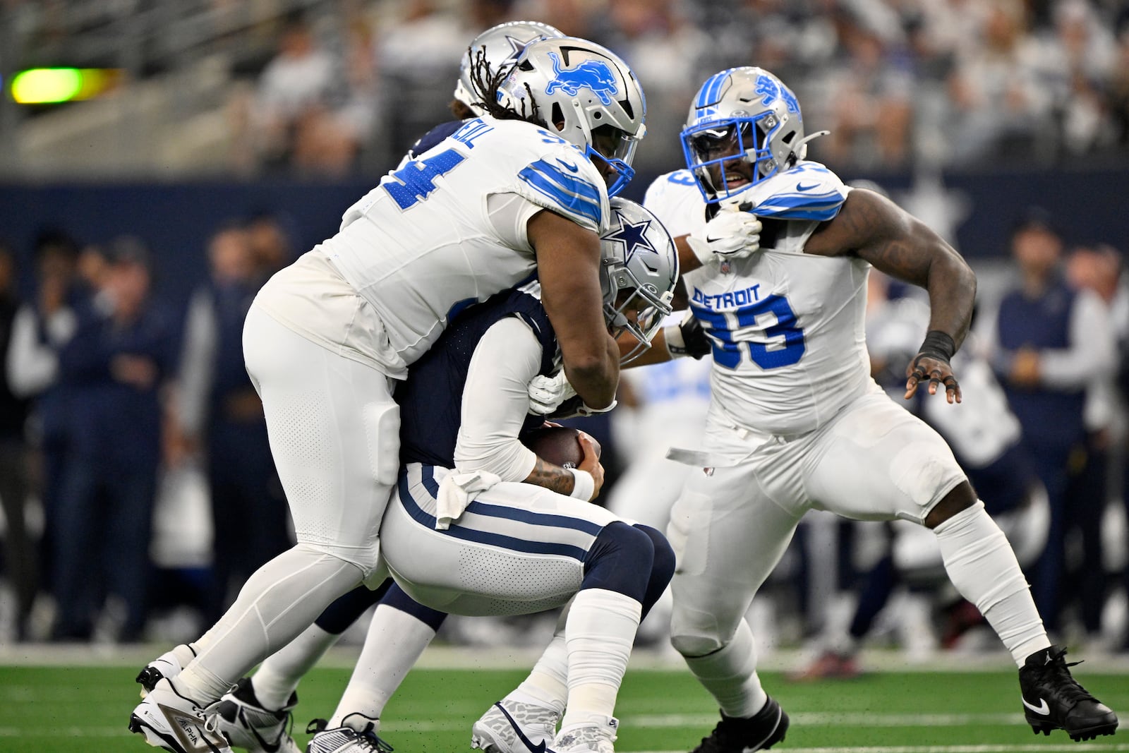 Detroit Lions defensive tackle Alim McNeill, left, sacks Dallas Cowboys quarterback Dak Prescott (4) as Josh Paschal (93) pressures in the first first half of an NFL football game in Arlington, Texas, Sunday, Oct. 13, 2024. (AP Photo/Jerome Miron)