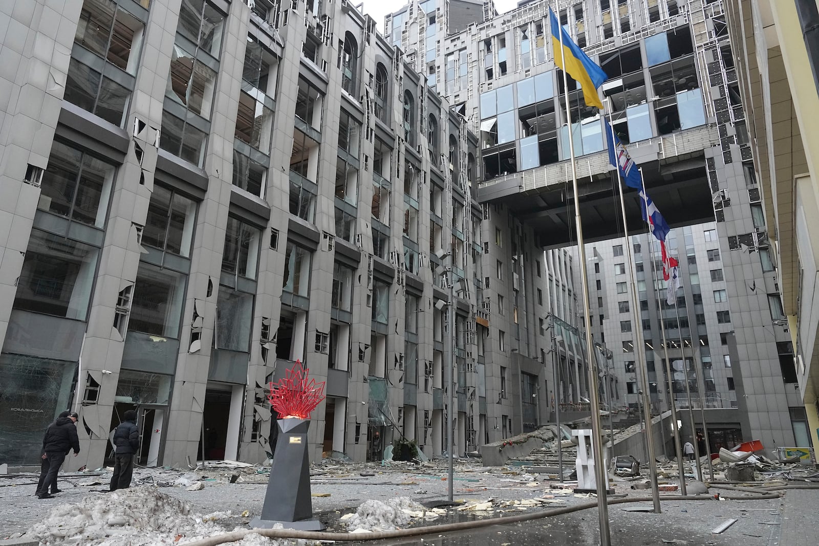 People stand next to buildings destroyed by the recent Russian attacks in Kyiv, Ukraine, Friday, Dec. 20, 2024. (AP Photo/Efrem Lukatsky)