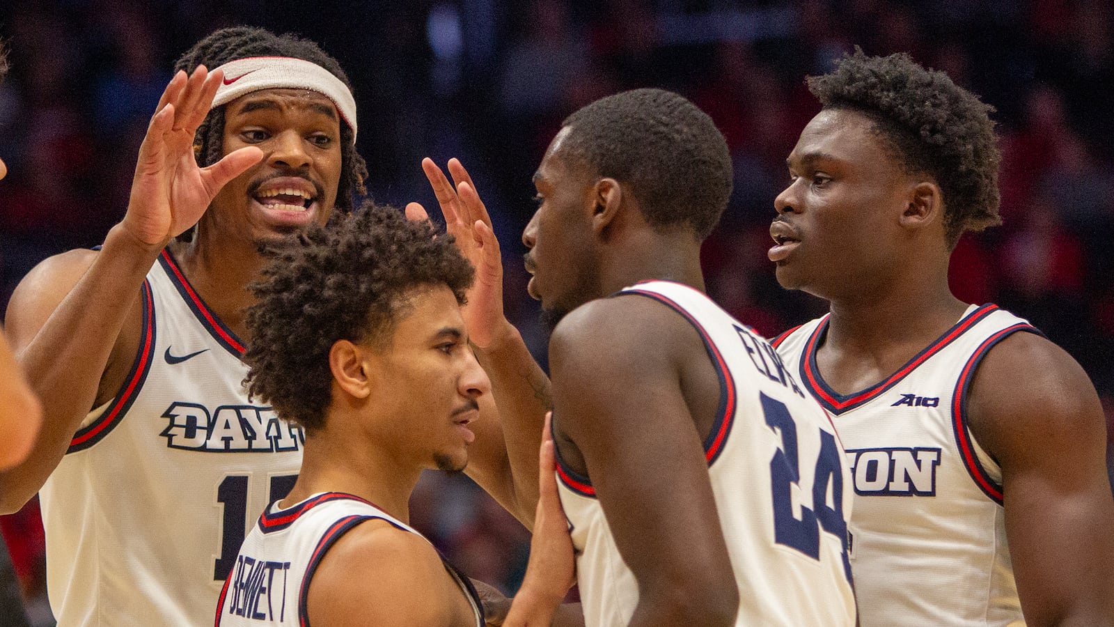 Left to right, DaRon Holmes II, Javon Bennett, Kobe Elvis and Enoch Cheeks huddle at the foul line during the first half Saturday in Dayton's 82-70 victory over Troy at UD Arena. Jeff Gilbert/CONTRIBUTED