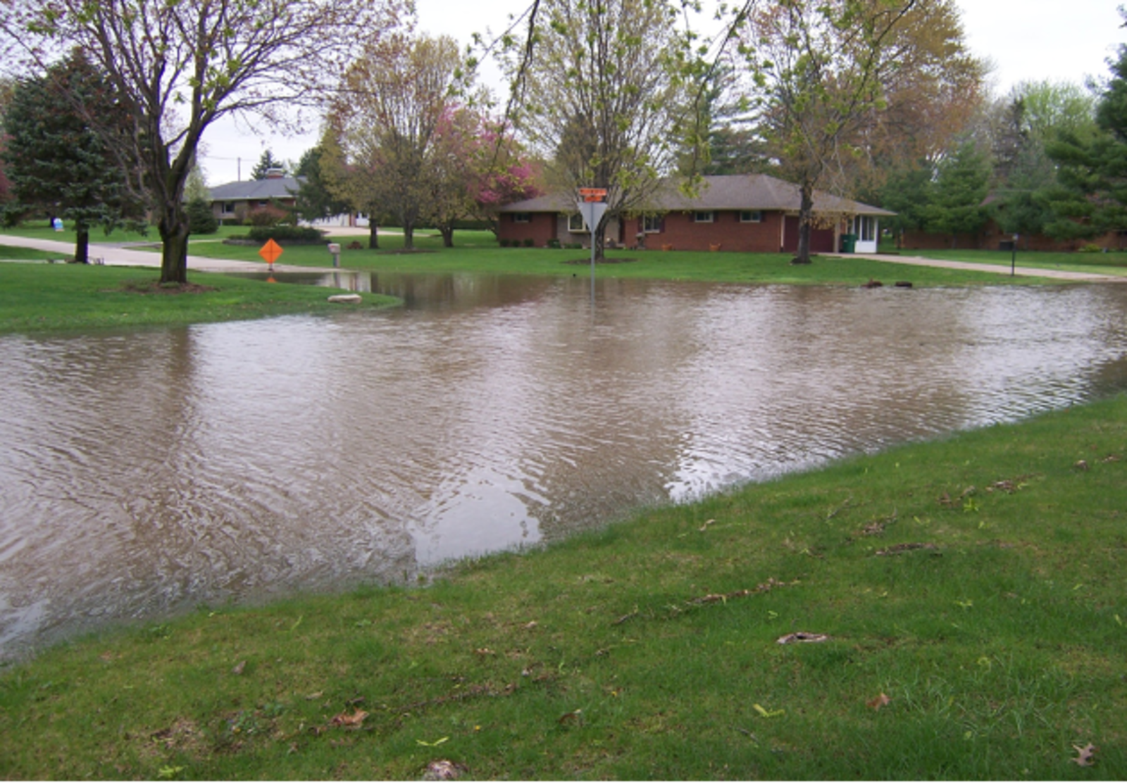 A heavily flooded neighborhood along Willowcrest Drive in Beavercreek. A sign in the back warns of standing water.