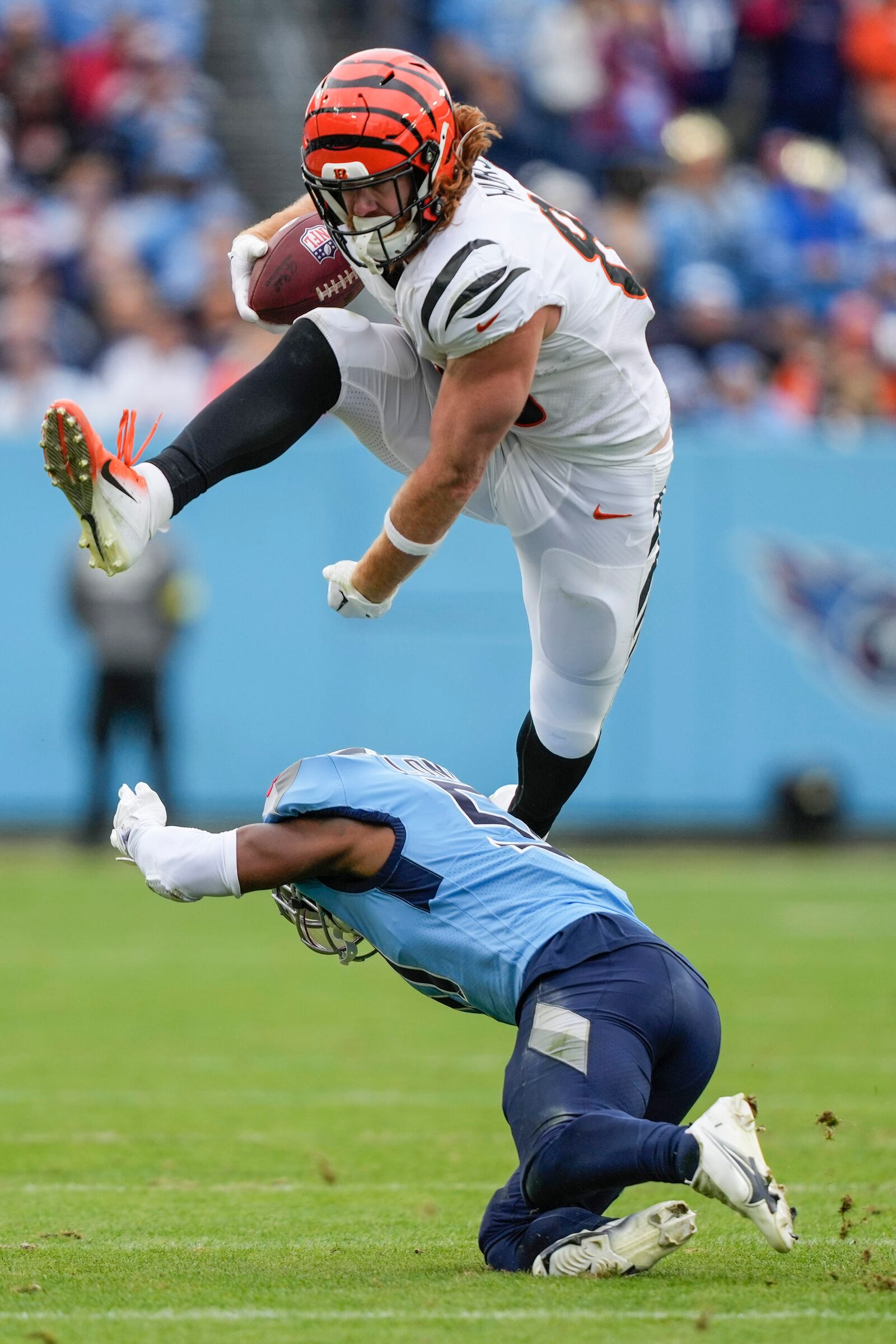 Cincinnati Bengals tight end Hayden Hurst (88) leaps over Tennessee Titans linebacker David Long Jr. (51) after a reception during the first half of an NFL football game, Sunday, Nov. 27, 2022, in Nashville, Tenn. (AP Photo/Gerald Herbert)