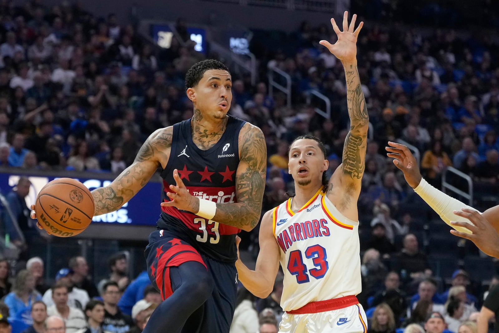 Washington Wizards forward Kyle Kuzma (33) passes the ball against Golden State Warriors forward Lindy Waters III (43) during the first half of an NBA basketball game in San Francisco, Saturday, Jan. 18, 2025. (AP Photo/Jeff Chiu)