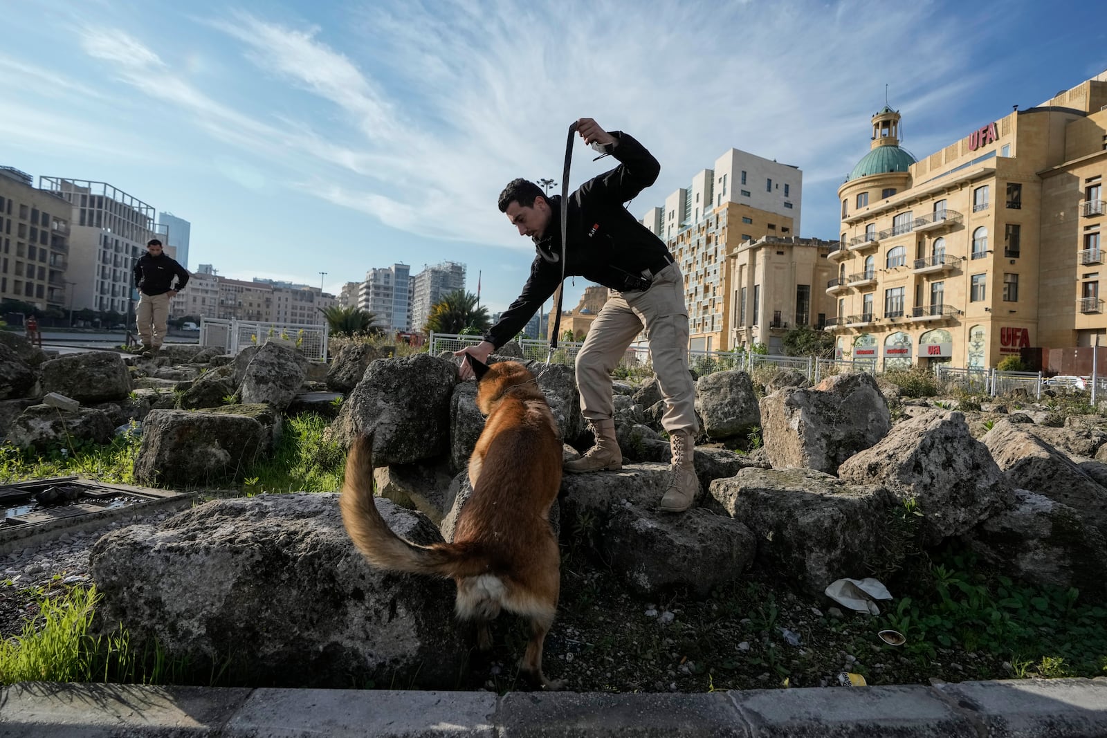 A Lebanese army soldier with a sniffer dog checks a road that leads to the parliament building while lawmakers gather to elect a president in Beirut, Lebanon, Thursday, Jan. 9, 2025. (AP Photo/Bilal Hussein)