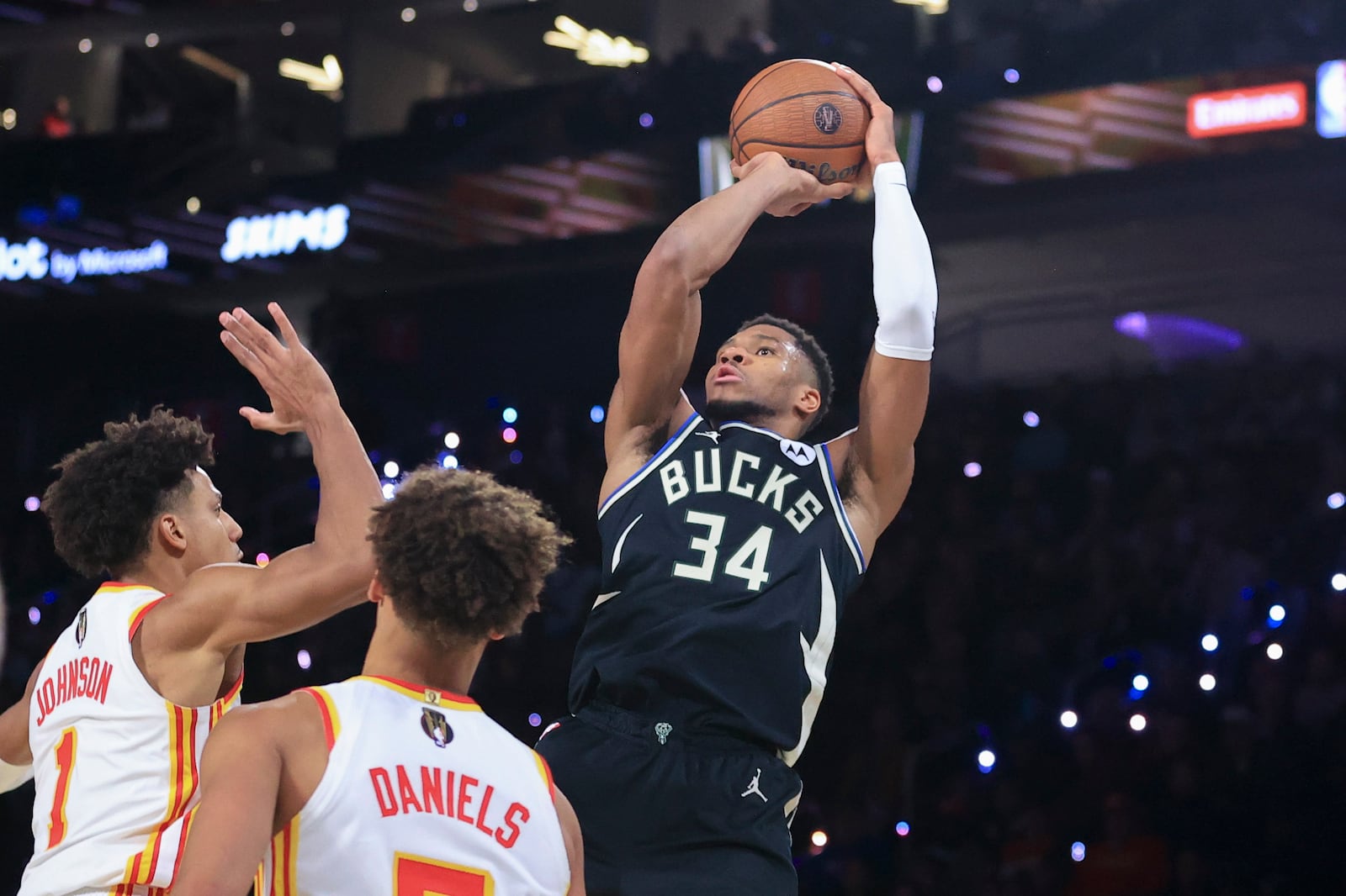 Milwaukee Bucks forward Giannis Antetokounmpo (34) goes up to shoot against Atlanta Hawks forward Jalen Johnson (1) and guard Dyson Daniels, second from left, during the second half of a semifinal game in the NBA Cup basketball tournament Saturday, Dec. 14, 2024, in Las Vegas. (AP Photo/Ian Maule)