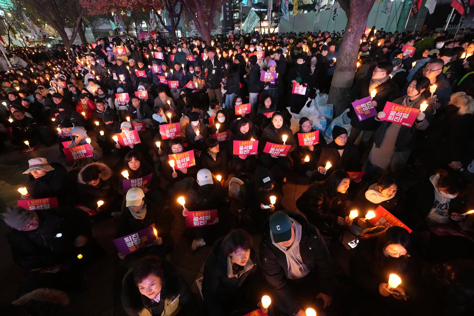 People hold candles during a candlelight vigil against South Korean President Yoon Suk Yeol in Seoul, South Korea, Wednesday, Dec. 4, 2024. (AP Photo/Lee Jin-man)