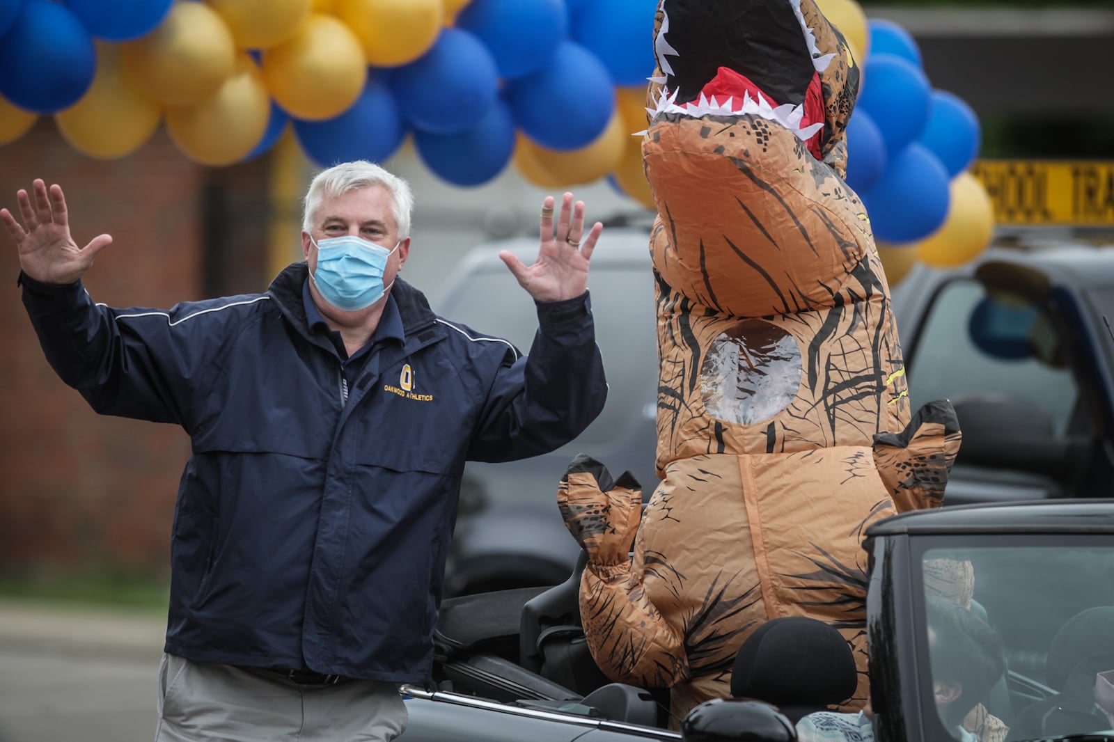 Oakwood High School Principal Paul Waller participates in a cap and gown drive-thru celebration behind the high school in May 2020 during COVID shutdowns. Seniors were encouraged to decorate their cars while teachers handed out caps, gowns and diplomas. STAFF PHOTO / JIM NOELKER