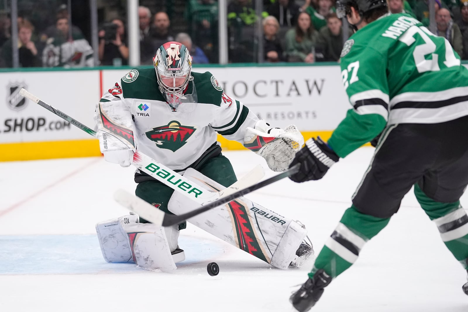 Minnesota Wild goaltender Filip Gustavsson (32) defends the goal against Dallas Stars left wing Mason Marchment (27) in the first period of an NHL hockey game Friday, Dec. 27, 2024, in Dallas. (AP Photo/LM Otero)