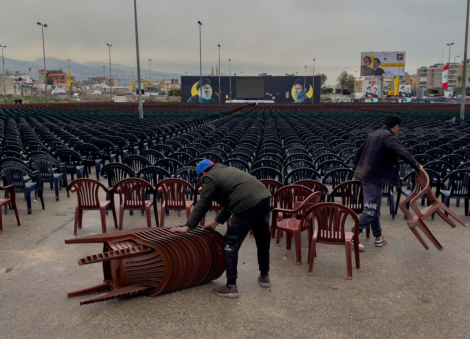 Workers set chairs outside Beirut's City Sportive stadium, a day ahead of the funeral procession of Hezbollah leaders Sayyed Hassan Nasrallah and Sayyed Hashem Safieddine, in Beirut, Lebanon, Saturday, Feb. 22, 2025. (AP Photo/Hussein Malla)