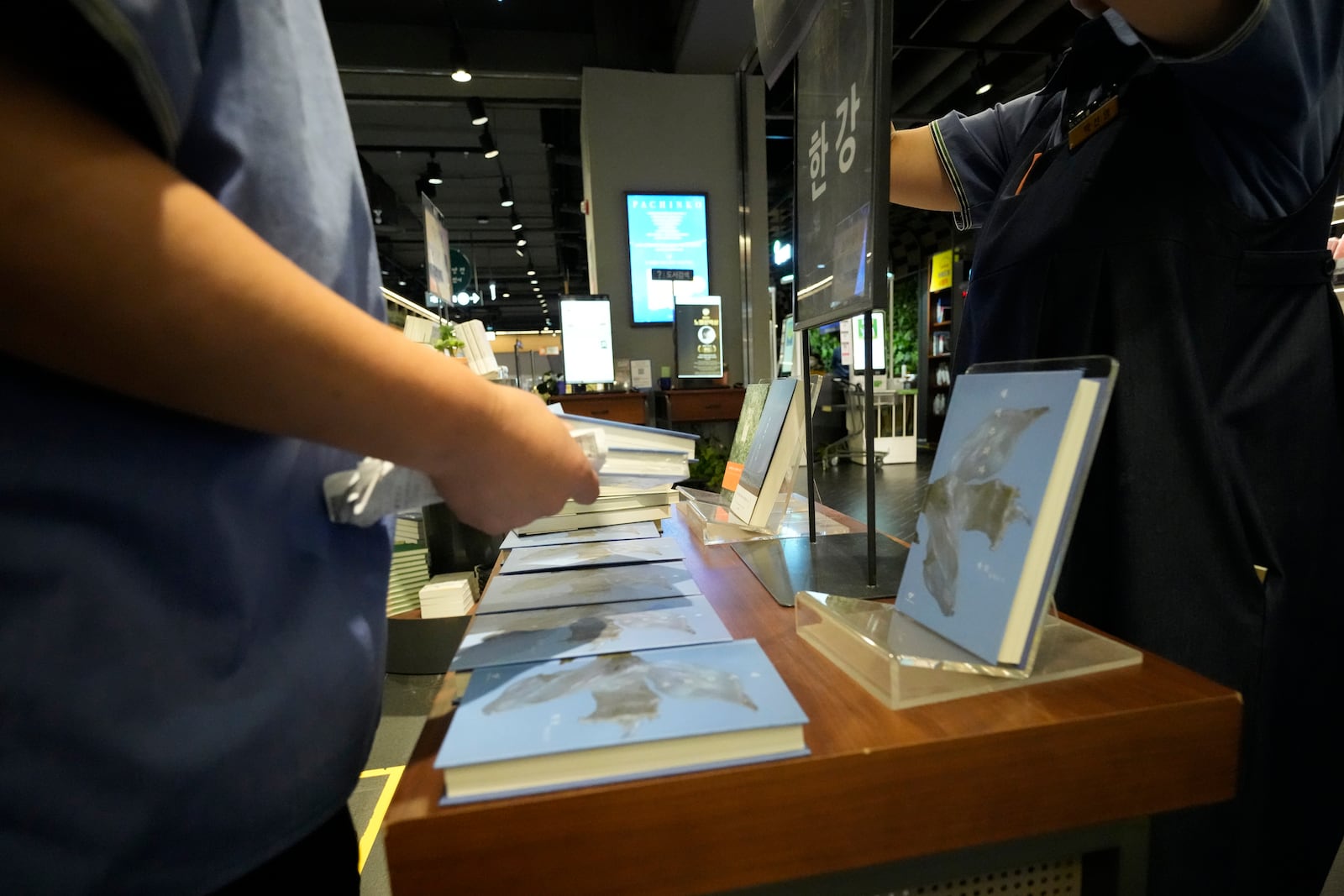 Workers display South Korean author Han Kang's books at a special section at a bookstore in Goyang, South Korea, Thursday, Oct. 10, 2024. The letters read "Han Kang, Awarded the Nobel Prize in literature." (AP Photo/Lee Jin-man)