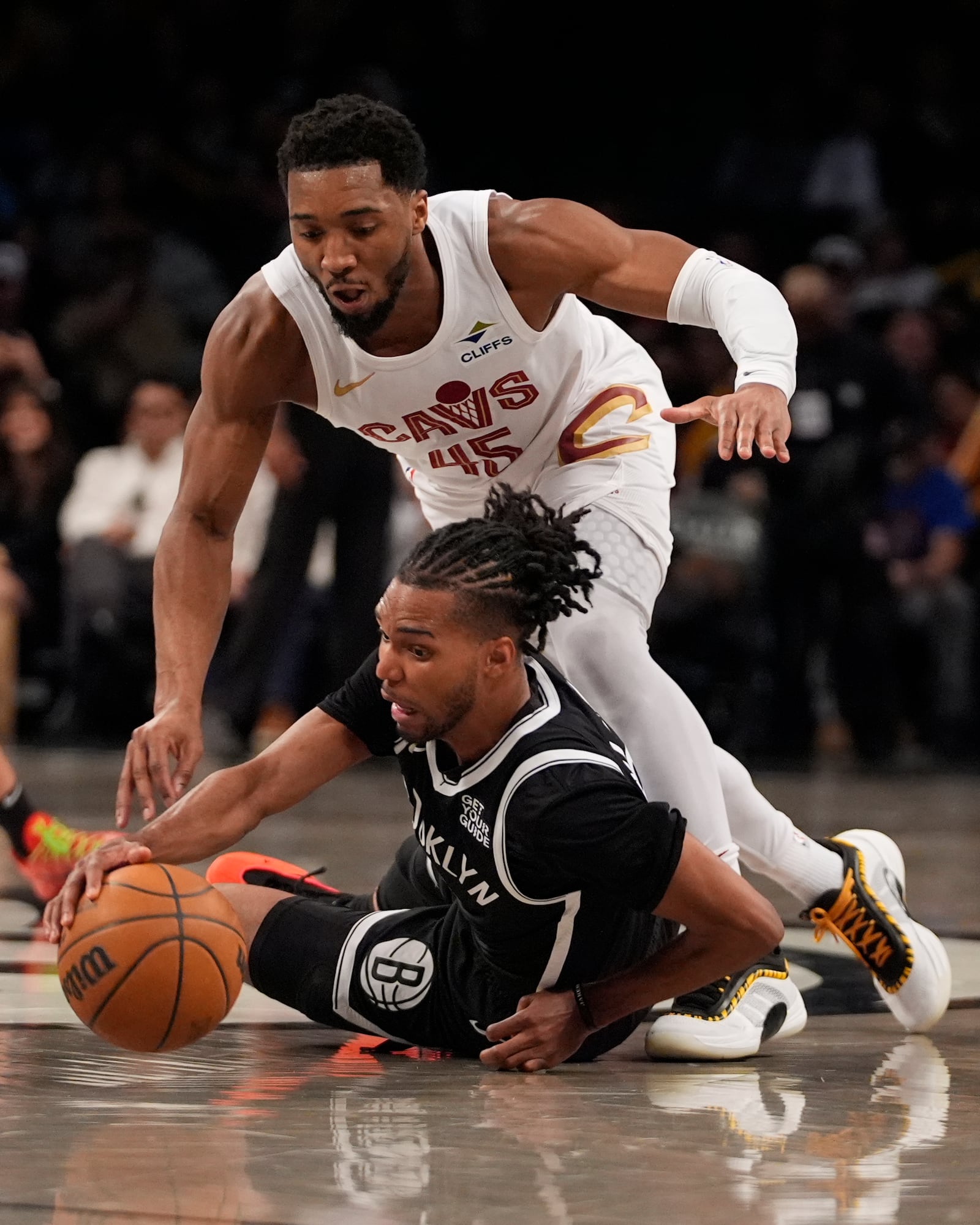 Cleveland Cavaliers' Donovan Mitchell (45) fights for control of the ball with Brooklyn Nets' Ziaire Williams (8) during the second half of an NBA basketball game Thursday, Feb. 20, 2025, in New York. (AP Photo/Frank Franklin II)