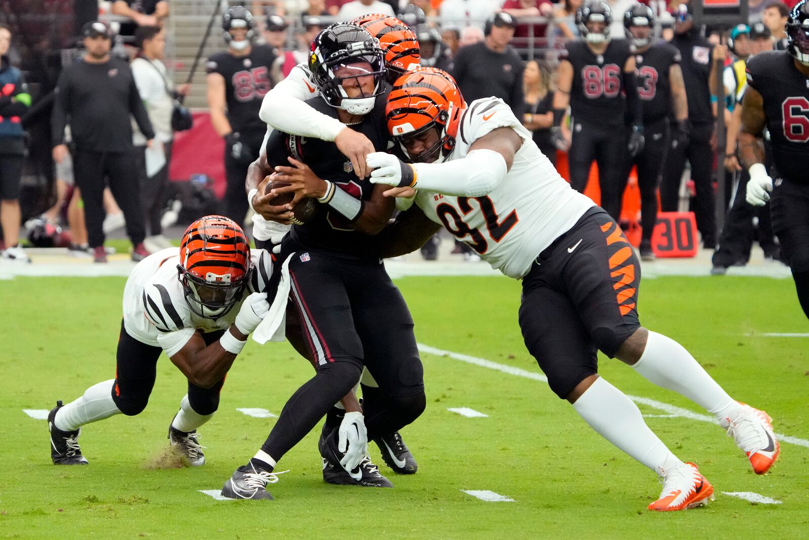 Arizona Cardinals quarterback Joshua Dobbs center, is sacked by Cincinnati Bengals defensive end Trey Hendrickson, rear, and Cincinnati Bengals defensive tackle BJ Hill (92) during an NFL football game, Sunday, Oct. 8, 2023, in Glendale, Ariz. (AP Photo/Rick Scuteri)