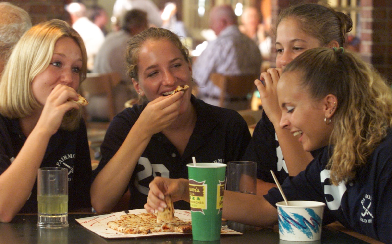 Ashley Peterson, Jamie Kremmel, Abby Pifer and Emily Campbell all members of the Fairmont High School Field Hockey team, enjoy some pizza after team pictures at the Marion's Piazza (cq)location at the Town and Country Shopping Center.  They waited for about  1/2 hour in line before being served. Marion's celebrated their 35 anniversary by rolling back their menu to 1965 prices.  Needless to say it was a huge success.  Store manager, Jim Randall figured they would serve 2000 large pizzas in the 12 hour span of the special event.