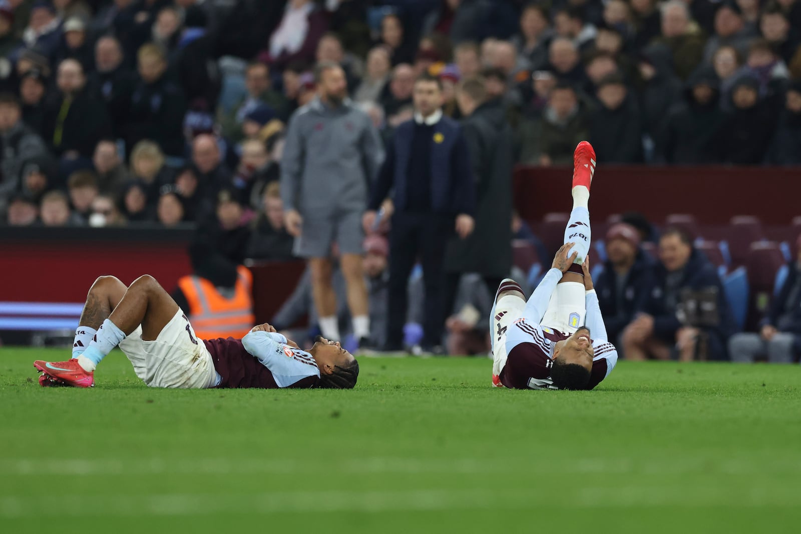 Aston Villa's Ezri Konsa, right, and Leon Bailey lies on the pitch after a challenge during the English FA Cup fifth round soccer match between Aston Villa and Cardiff City at the Villa Park stadium in Birmingham, England, Friday, Feb. 28, 2025. (AP Photo/Darren Staples)