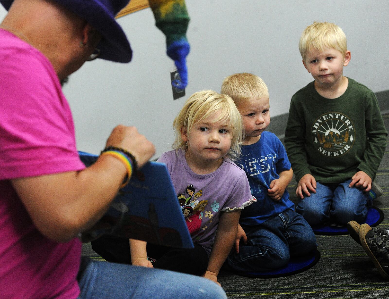 Tim Capehart, Beavercreek Library head of youth services, reads a story to Annmarie Mitchell, Wesley Bixel and Elias Bixel, during Preschool Story-time at the library, June 14, 2023. MARSHALL GORBY\STAFF