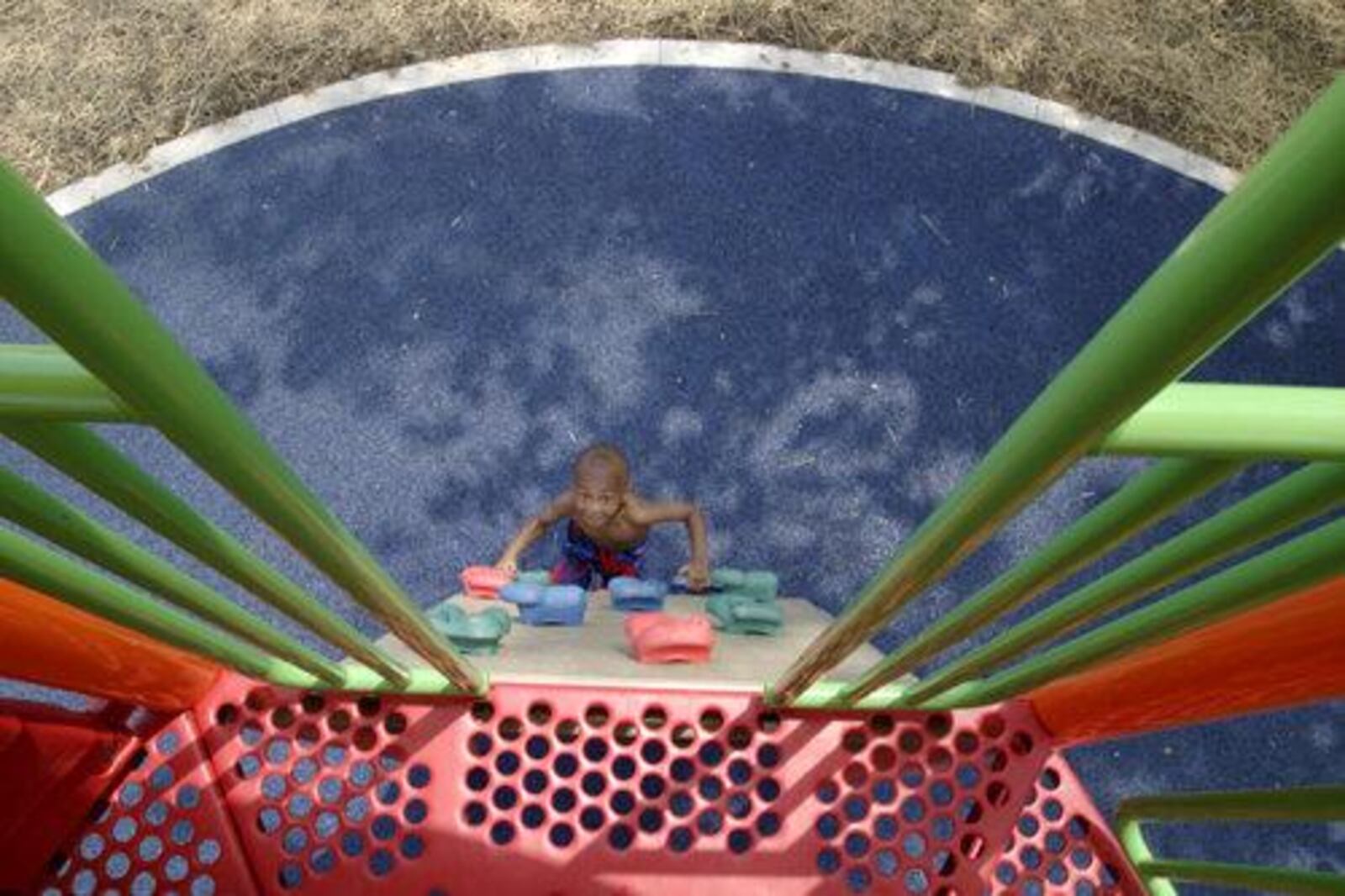 Jamarcus Anderson, 3 of Dayton climbs a tower during the grand opening of the Fairview Commons Spray Park and Playground on Elsmere Avenue in Dayton, Saturday, June 11, 2011.