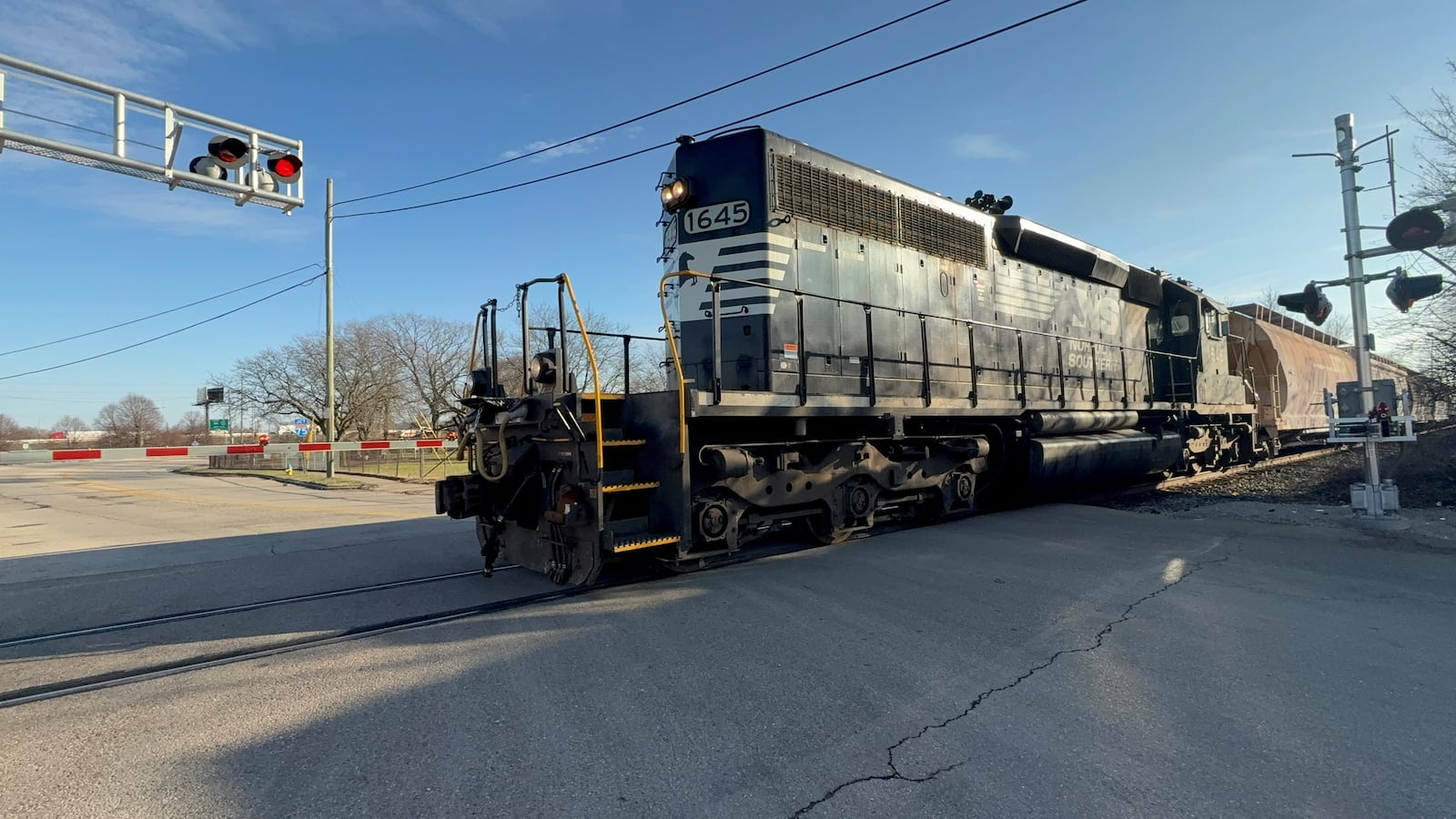 A Norfolk Southern freight train approaches an at-grade rail crossing on West Stewart Street in Dayton's Edgemont neighborhood in late December 2024. CORNELIUS FROLIK / STAFF