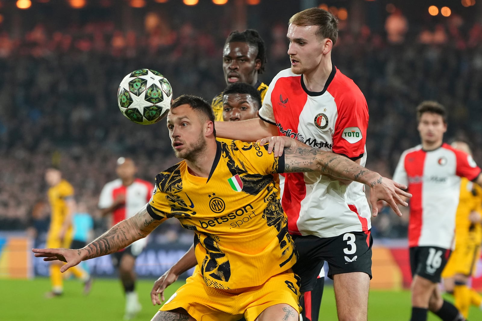 Inter Milan's Marko Arnautovic, front , and Feyenoord's Thomas Beelen fight for the ball during the Champions League round of 16 first leg soccer match between Feyenoord and Inter Milan in Rotterdam, Netherlands, Wednesday, March 5, 2025. (AP Photo/Peter Dejong)