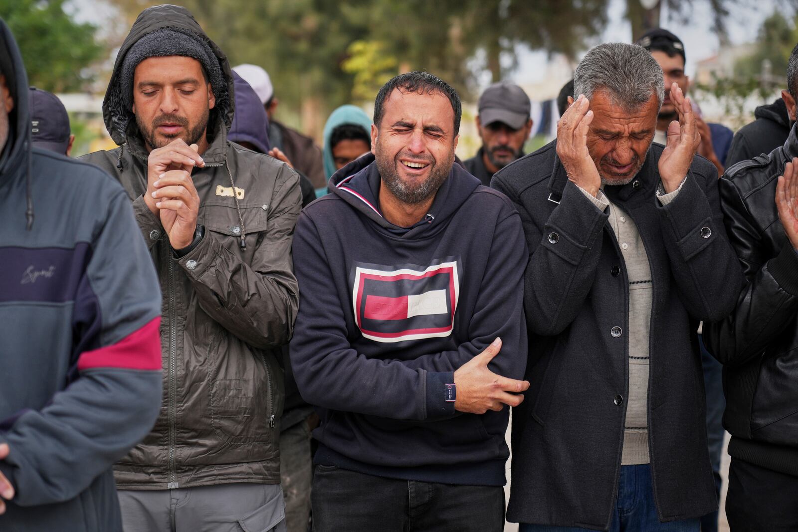 A Palestinian man weeps as he prays during a mass burial ceremony for victims of Israeli army strikes in Khan Younis, southern Gaza Strip, Thursday, March 20, 2025. (AP Photo/Abdel Kareem Hana)