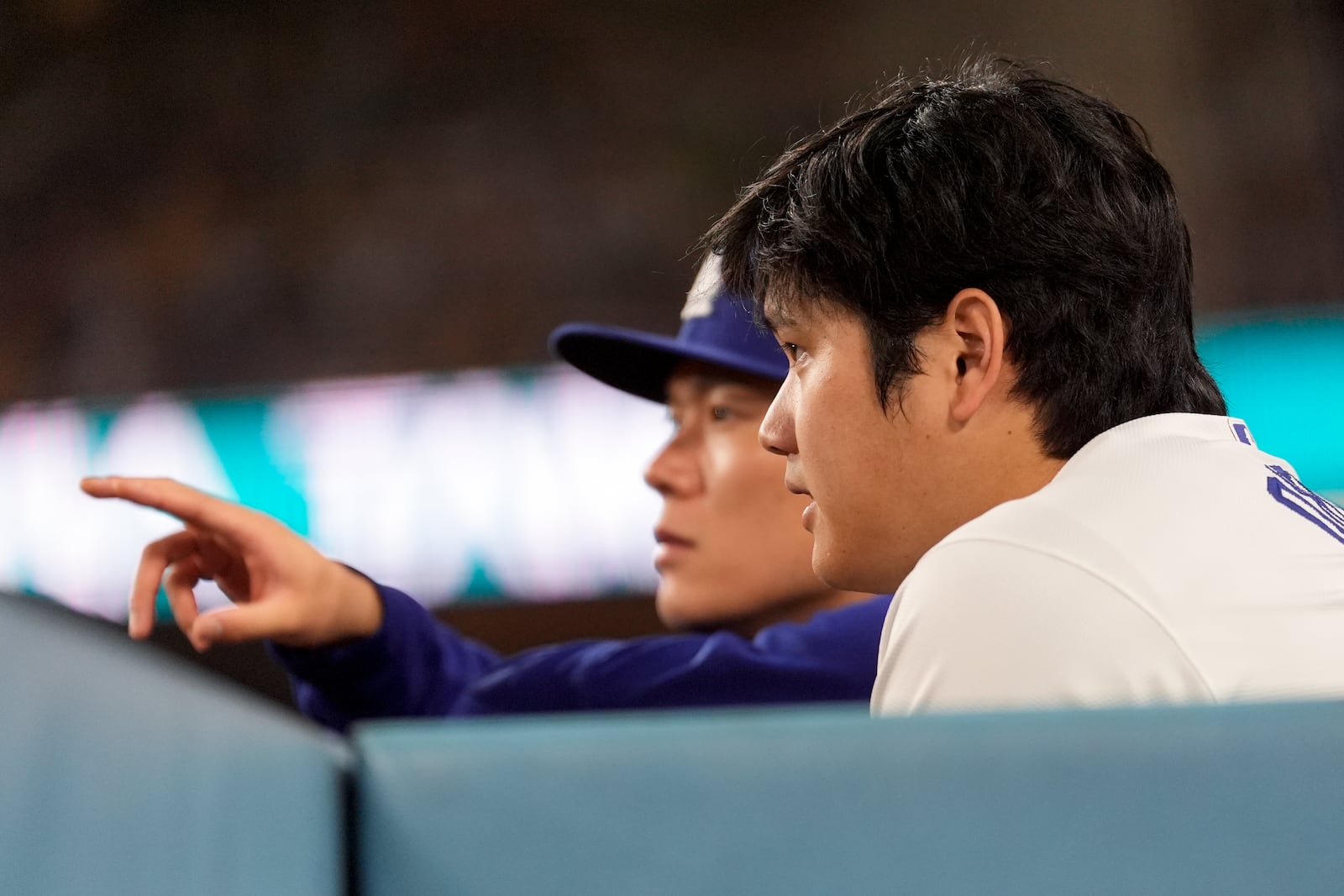 Los Angeles Dodgers' Shohei Ohtani and pitcher Yoshinobu Yamamoto watch during the sixth inning in Game 6 of a baseball NL Championship Series against the New York Mets, Sunday, Oct. 20, 2024, in Los Angeles. (AP Photo/Ashley Landis)