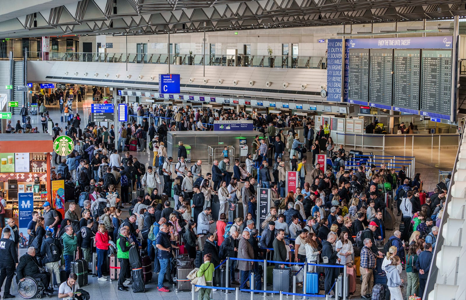 People queue in long lines in departure hall C at Rhine-Main Airport, Frankfurt, Germany, Sunday March 9, 2025, a day ahead of a planned strike across Germany amid new contract negotiations. (Andreas Arnold/dpa via AP)