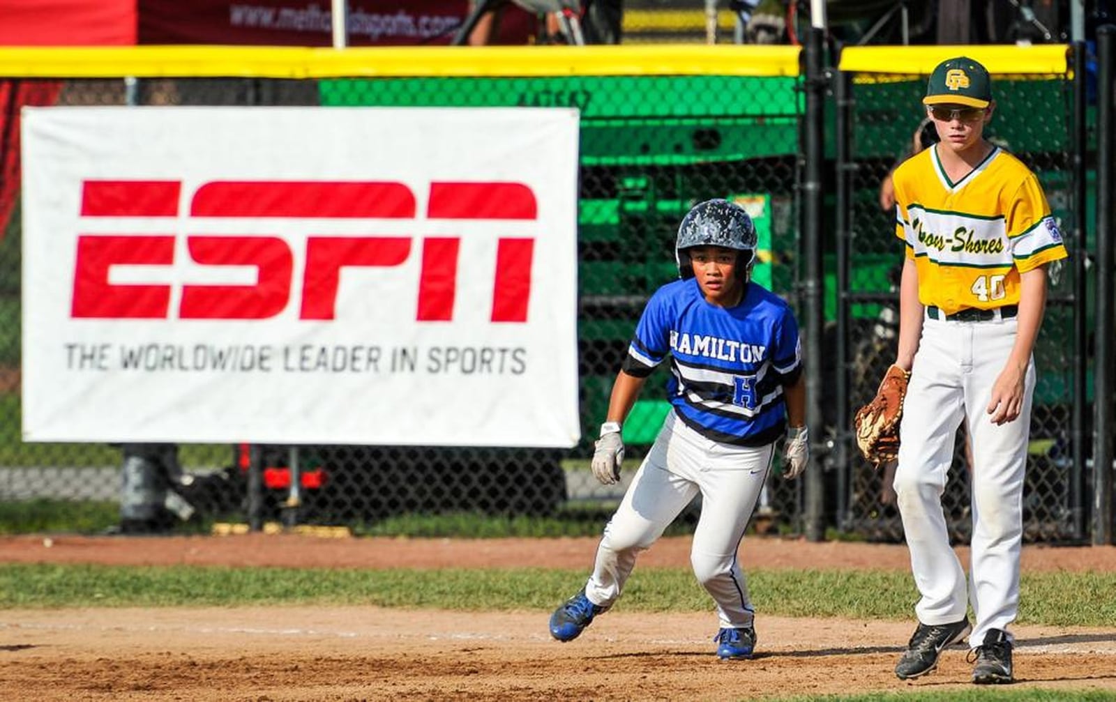 Hamilton West Side’s Katelyn Polido rounds first base as Adam Ayrault of Grosse Pointe Woods-Shores (Mich.) looks for the ball during Hamilton’s 11-3 loss in the 2017 Little League Great Lakes Regional at Grand Park Sports Campus in Westfield, Ind. NICK GRAHAM/STAFF