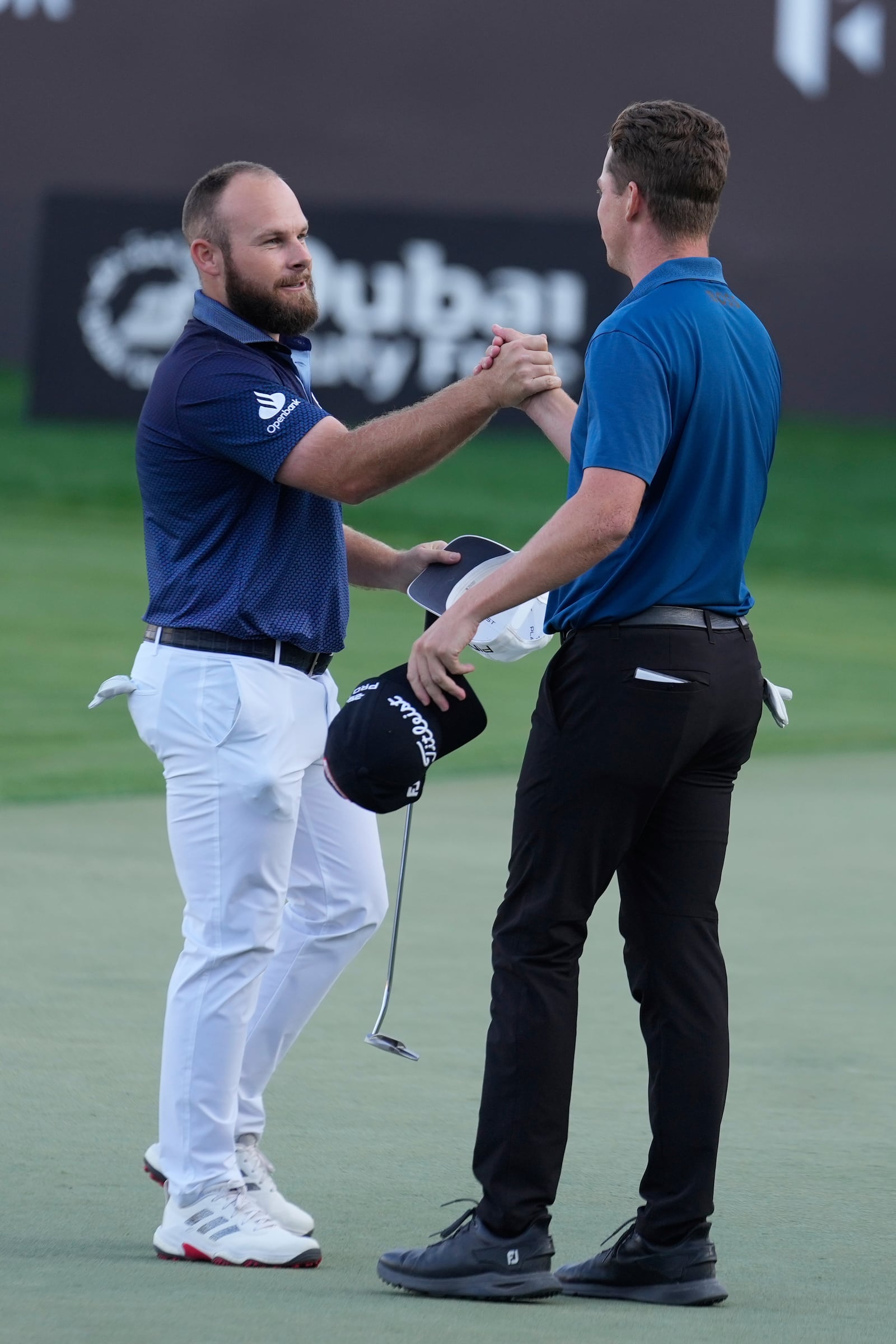 Tyrell Hatton of England, left, is congratulated by Daniel Hillier of New Zealand after Hatton won the Dubai Desert Classic golf tournament, in Dubai, United Arab Emirates, Sunday, Jan. 19, 2025. (AP Photo/Altaf Qadri)