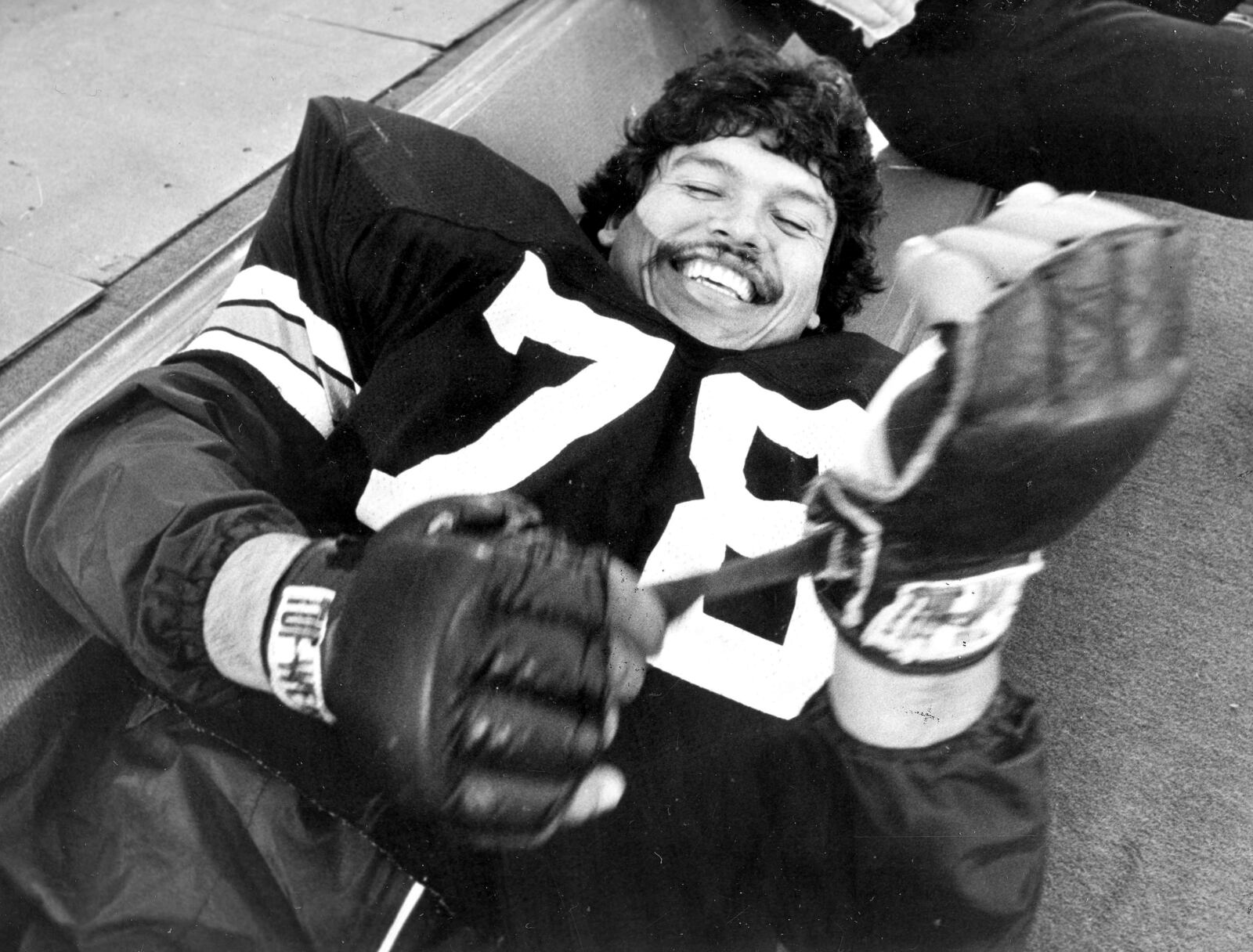 FILE - Cincinnati Bengals tackle Anthony Munoz tightens his glove before an NFL football practice session at the Silverdome in Pontiac, Mich., Jan. 23, 1982. Players from the 1988 Bengals Super Bowl team are reveling the success in the current team, which is playing in the AFC championship game Sunday, Jan. 30, 2022, in Kansas City. (AP Photo/File)