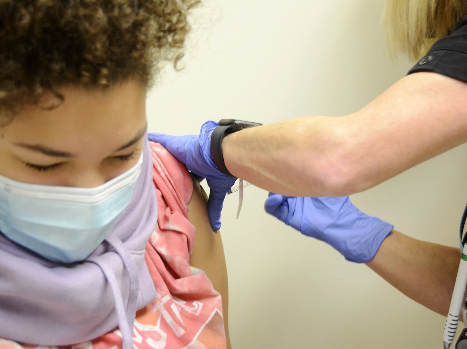 Brooklyn Brundidge, 12, a seventh-grader at Garfield Middle School in Hamilton, receives a vaccine shot on Wednesday, Sept. 14, 2022, from Public Health Nurse Betsy Waldeck at the Butler County General Health District clinic in downtown Hamilton. MICHAEL D. PITMAN/STAFF