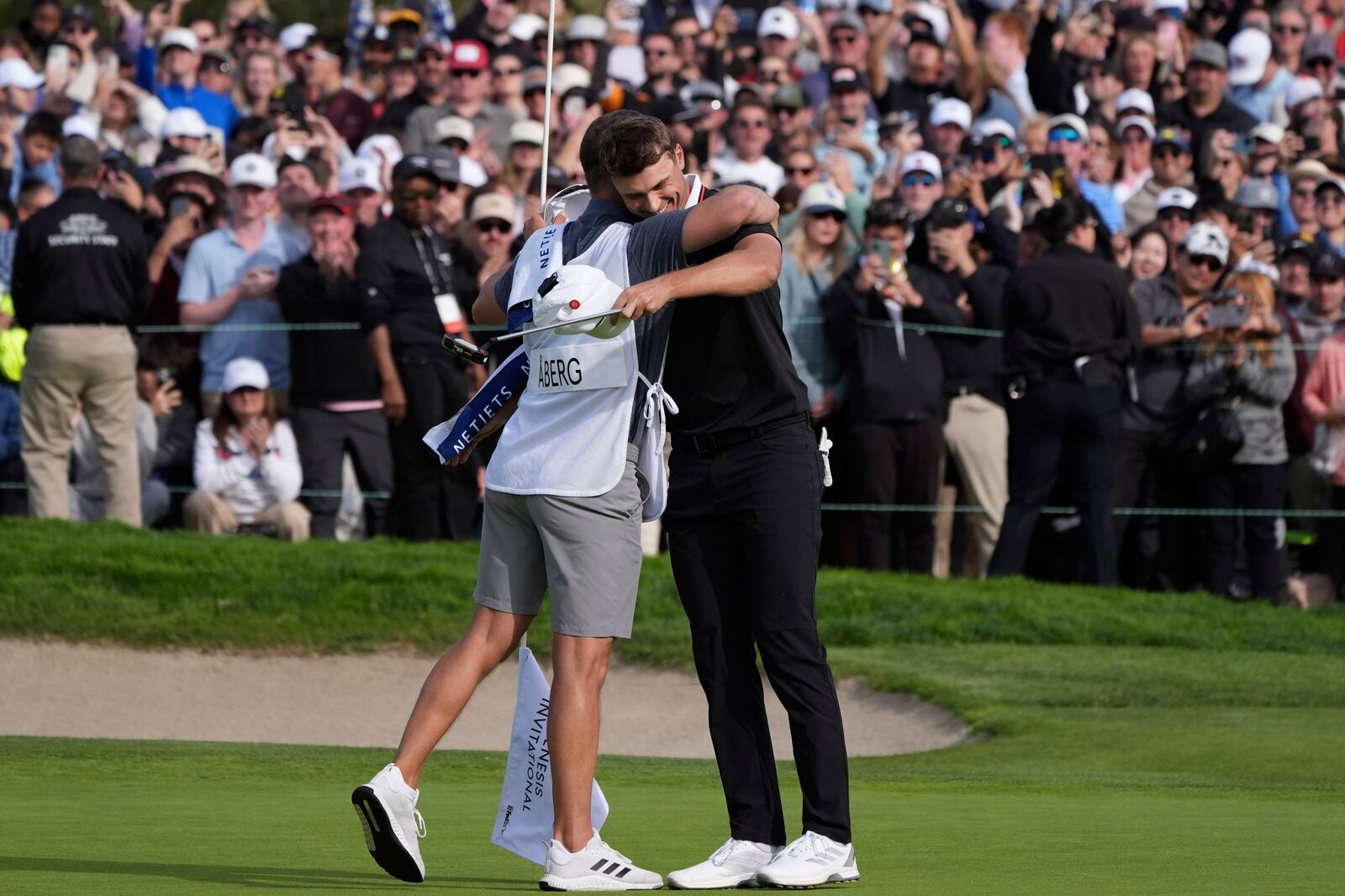 Ludvig Åberg, of Sweden, right, celebrates after making a birdie putt on the 18th green of the South Course at Torrey Pines during the final round of the Genesis Invitational golf tournament Sunday, Feb. 16, 2025, in San Diego. (AP Photo/Gregory Bull)