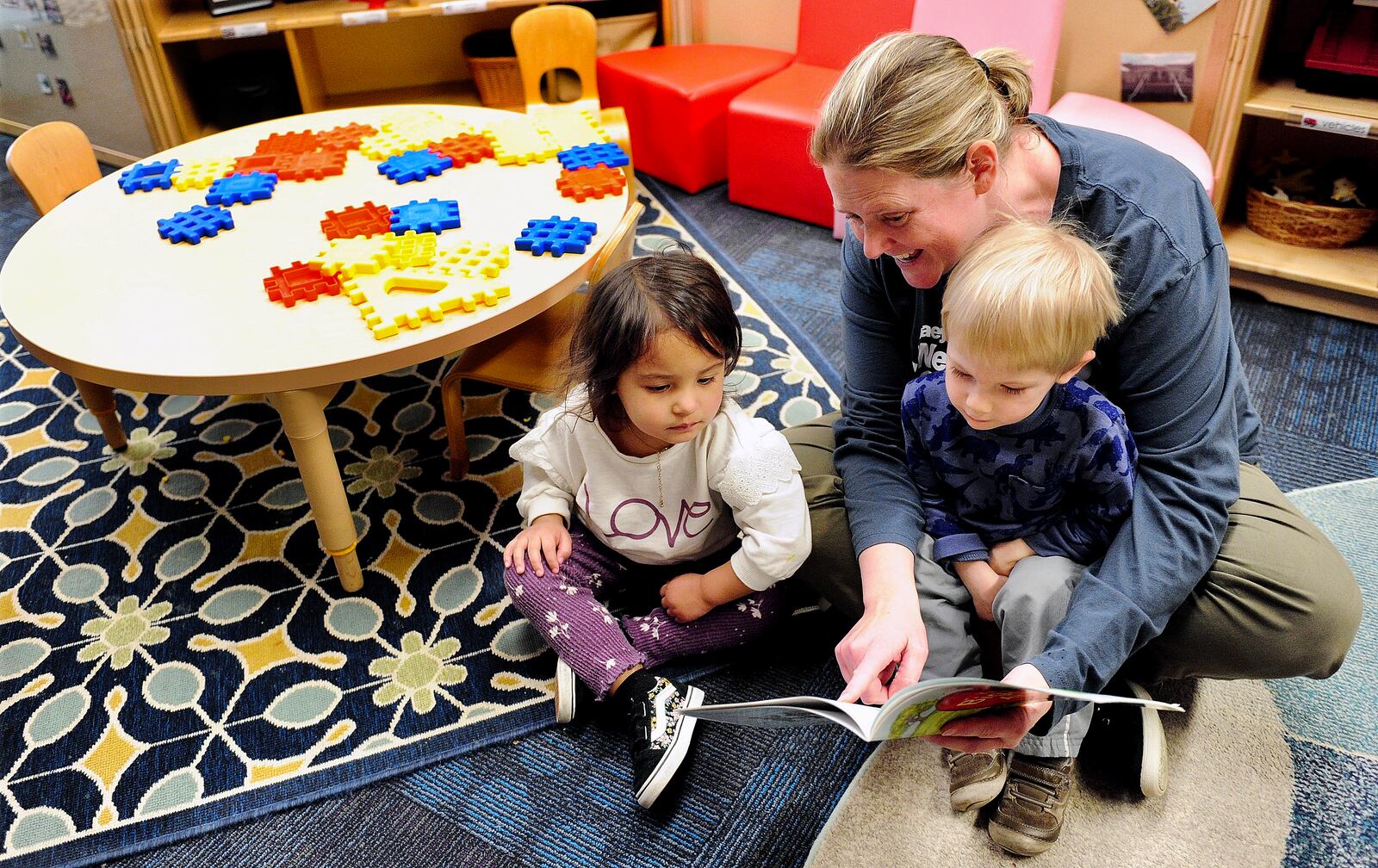 Ashley Boyce, a teacher at the Sinclair Mini University reads the “The Biggest Apple” to children Wednesday March 9, 2022. MARSHALL GORBY\STAFF