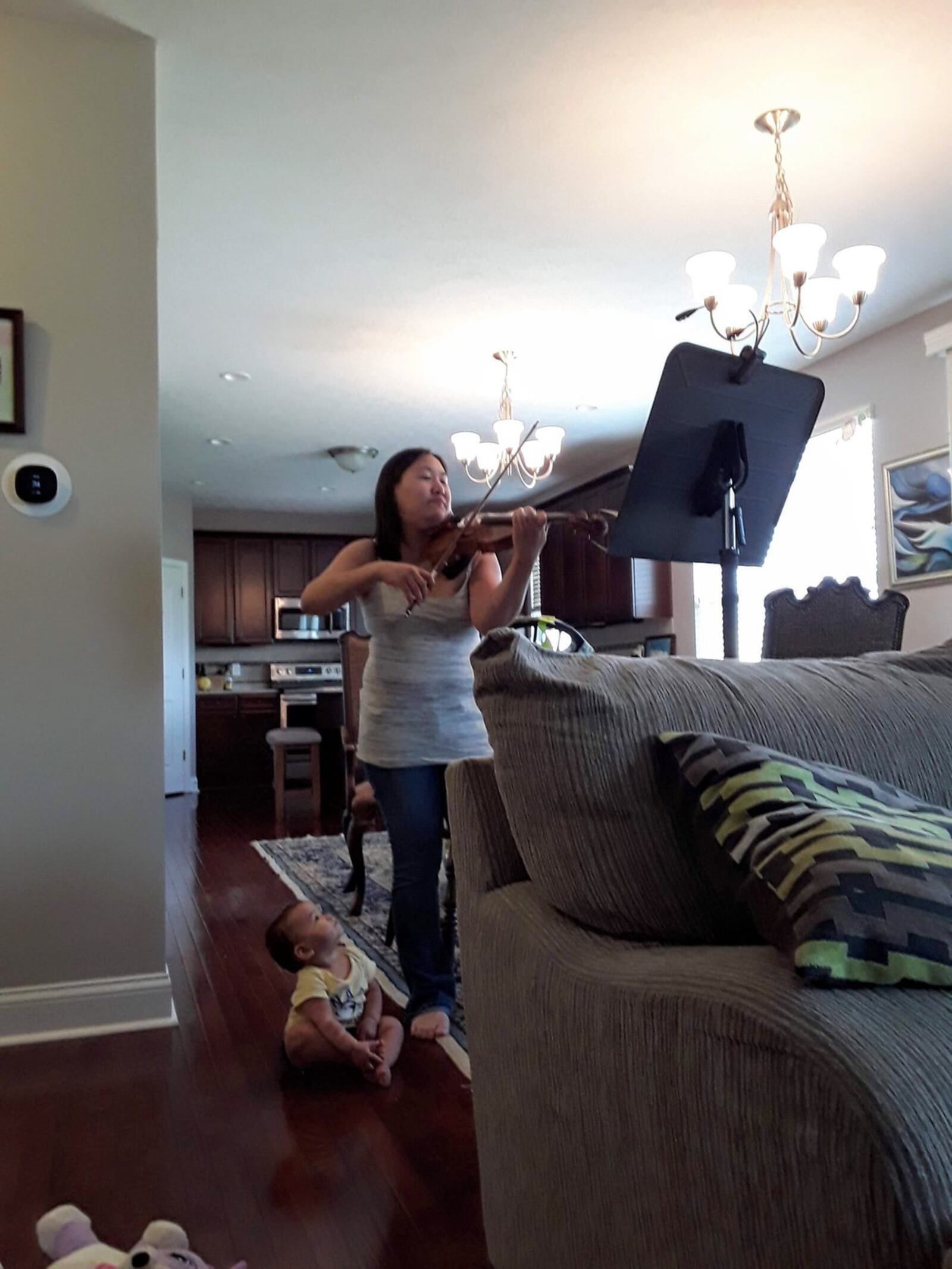 The Dayton Philharmonic Orchestra’s concertmaster Jessica Hung practices the violin at home with an appreciative audience. PROVIDED