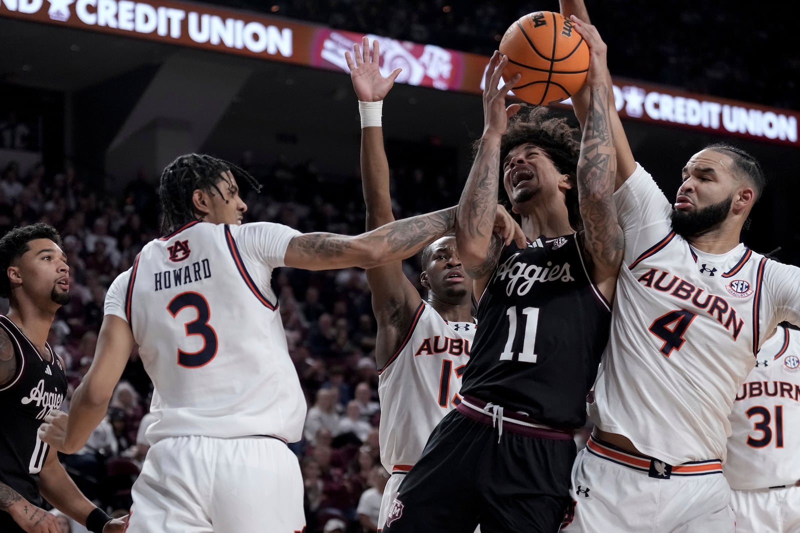 Texas A&M forward Andersson Garcia (11) is fouled on a shot by Auburn forward Jahki Howard (3) as teammate Johni Broome (4) defends during the first half of an NCAA college basketball game, Tuesday, March 4, 2025, in College Station, Texas. (AP Photo/Sam Craft)