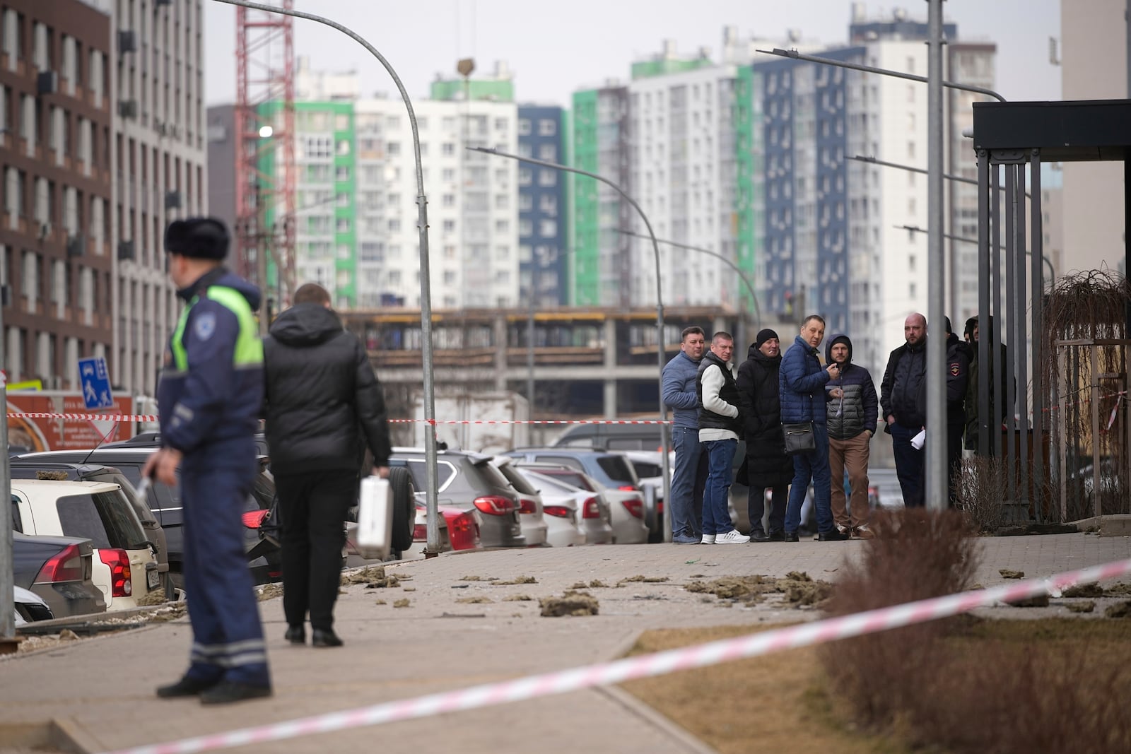 A police officer patrols an area as people gather near an apartment building where a downed Ukrainian drone fell in Sapronovo village outside Moscow, Russia, on Tuesday, March 11, 2025. (AP Photo)